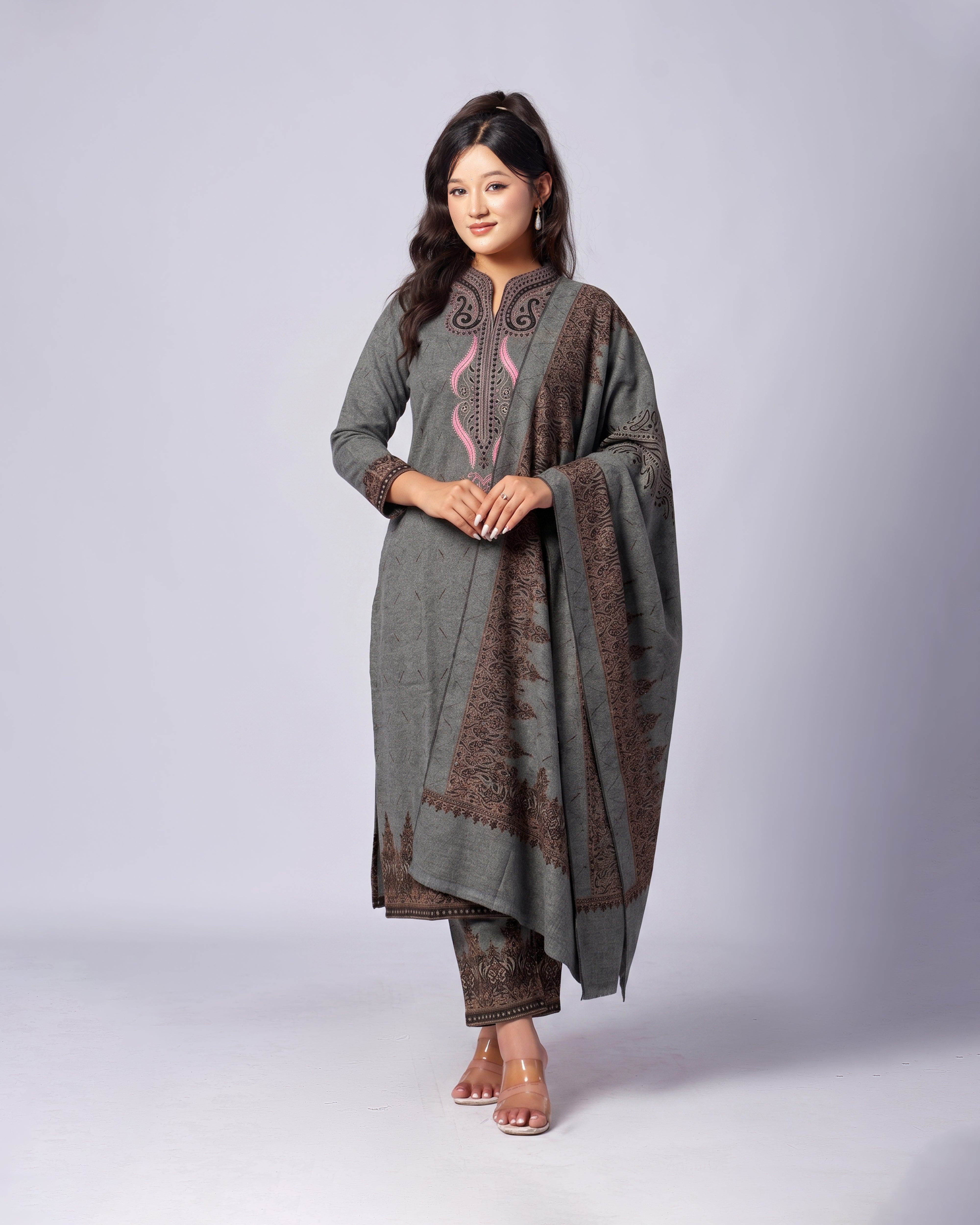 Woman wearing a traditional outfit with a gray and brown patterned dress on a white background