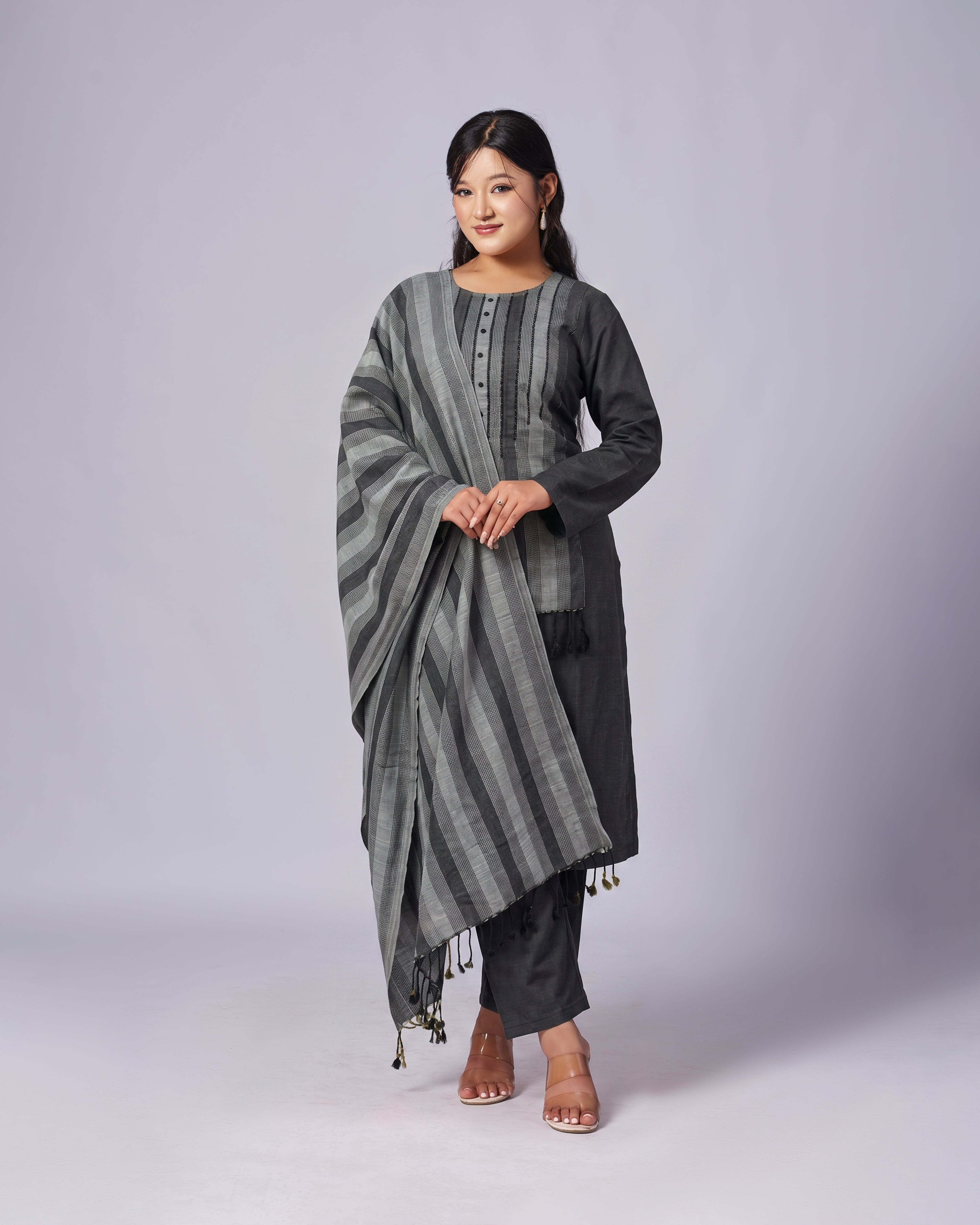 Woman wearing a black and gray striped traditional outfit on a white background
