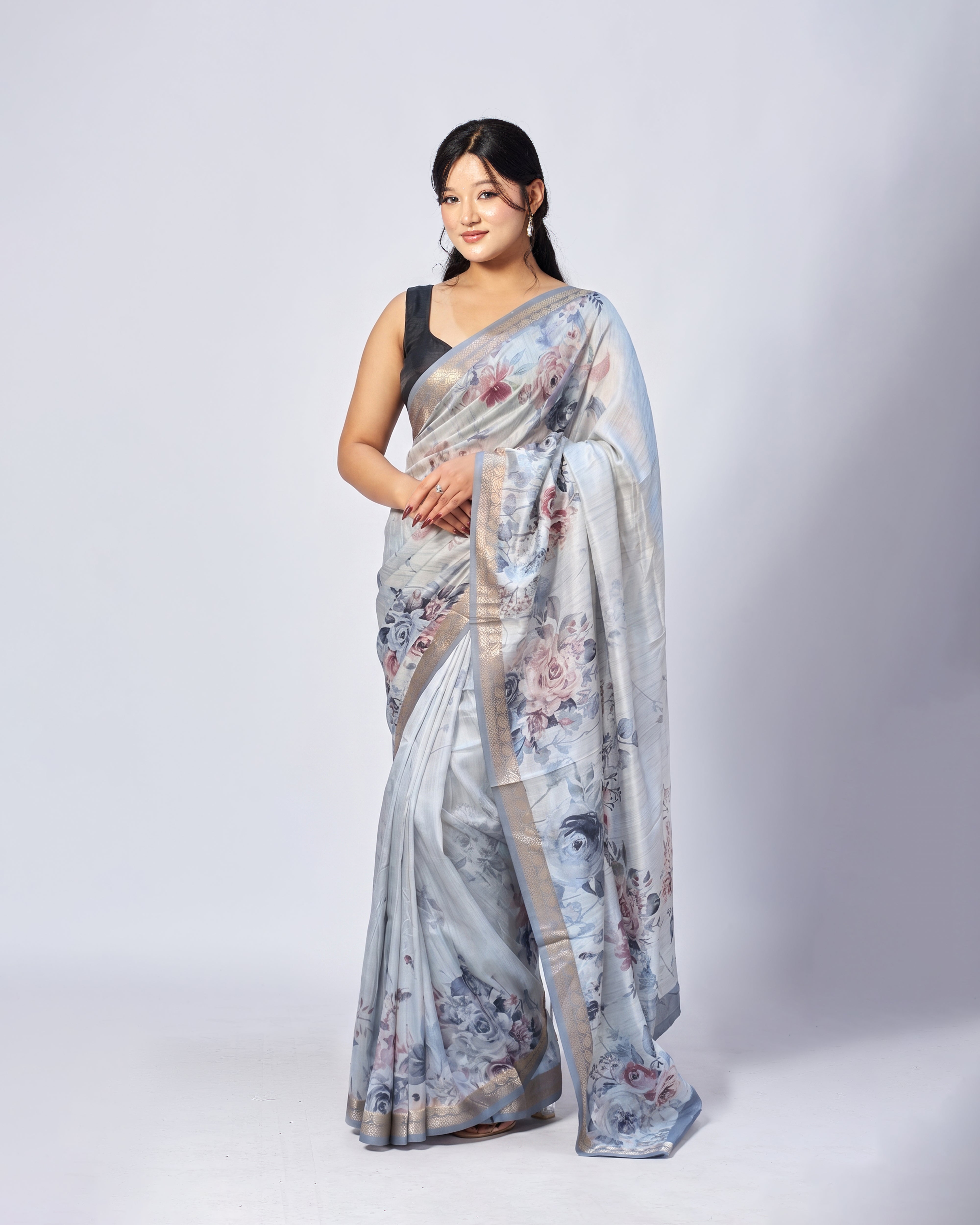 Woman wearing a floral saree with a plain background