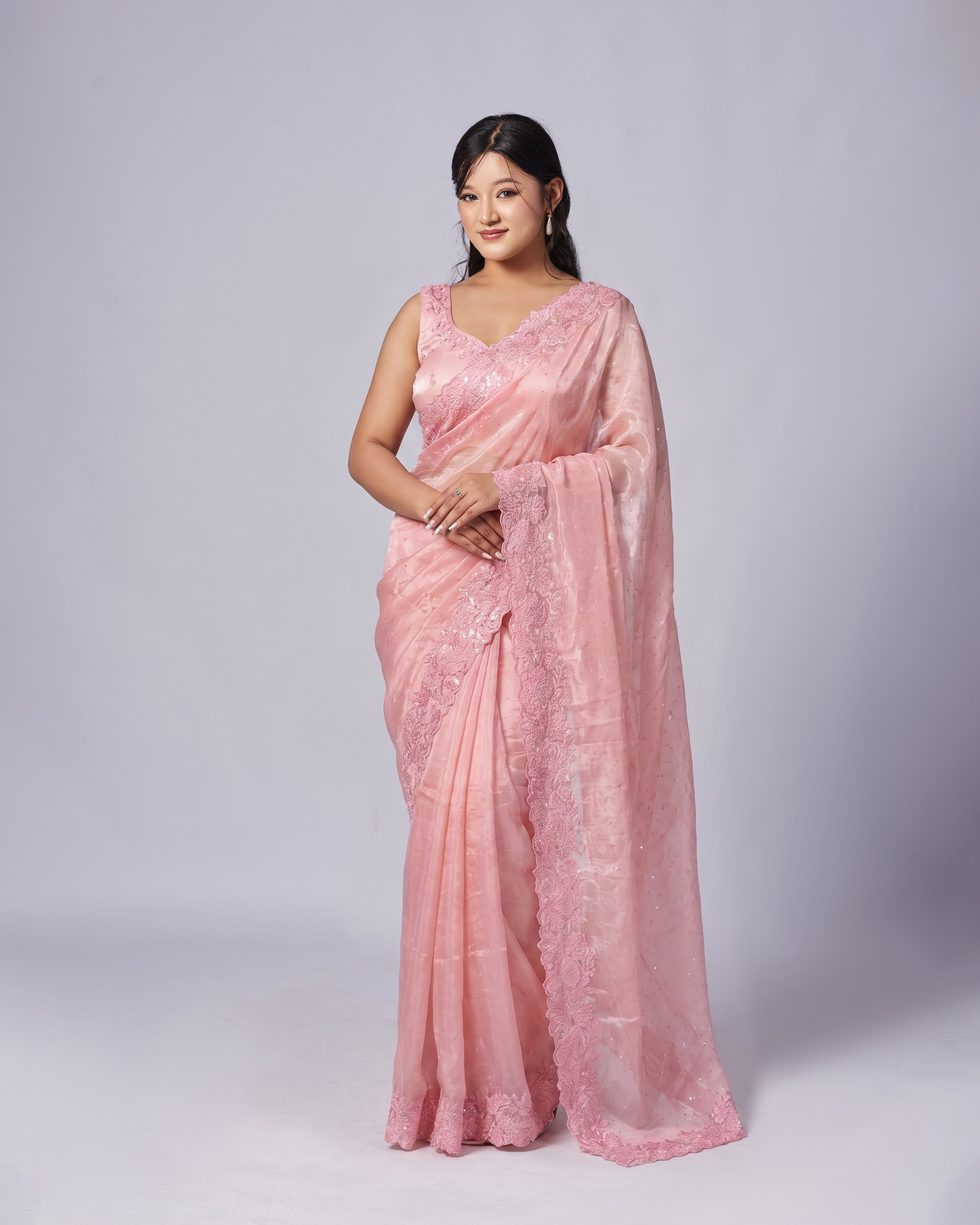 Woman wearing a pink saree with a white background