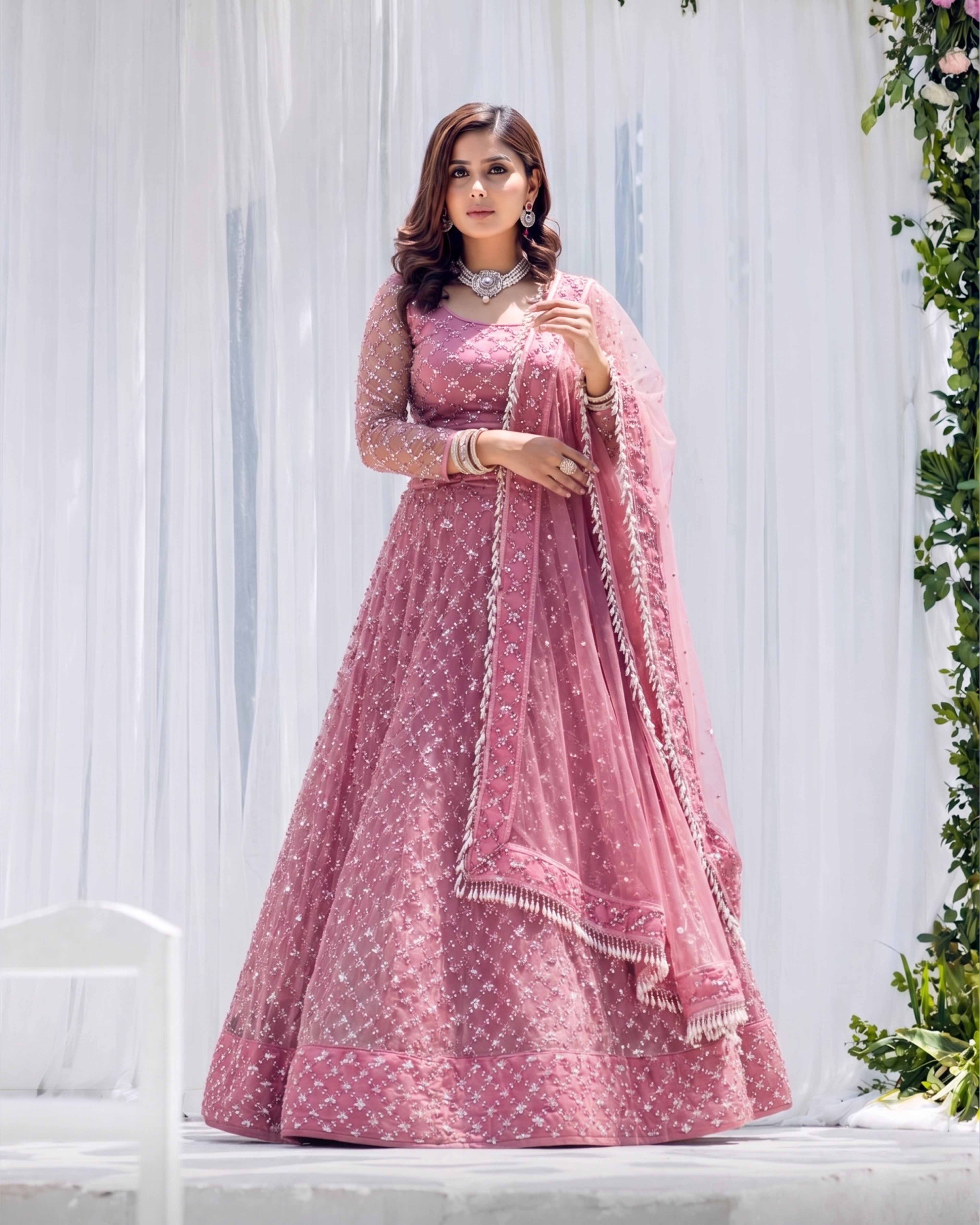 Woman in a pink traditional outfit with a white background