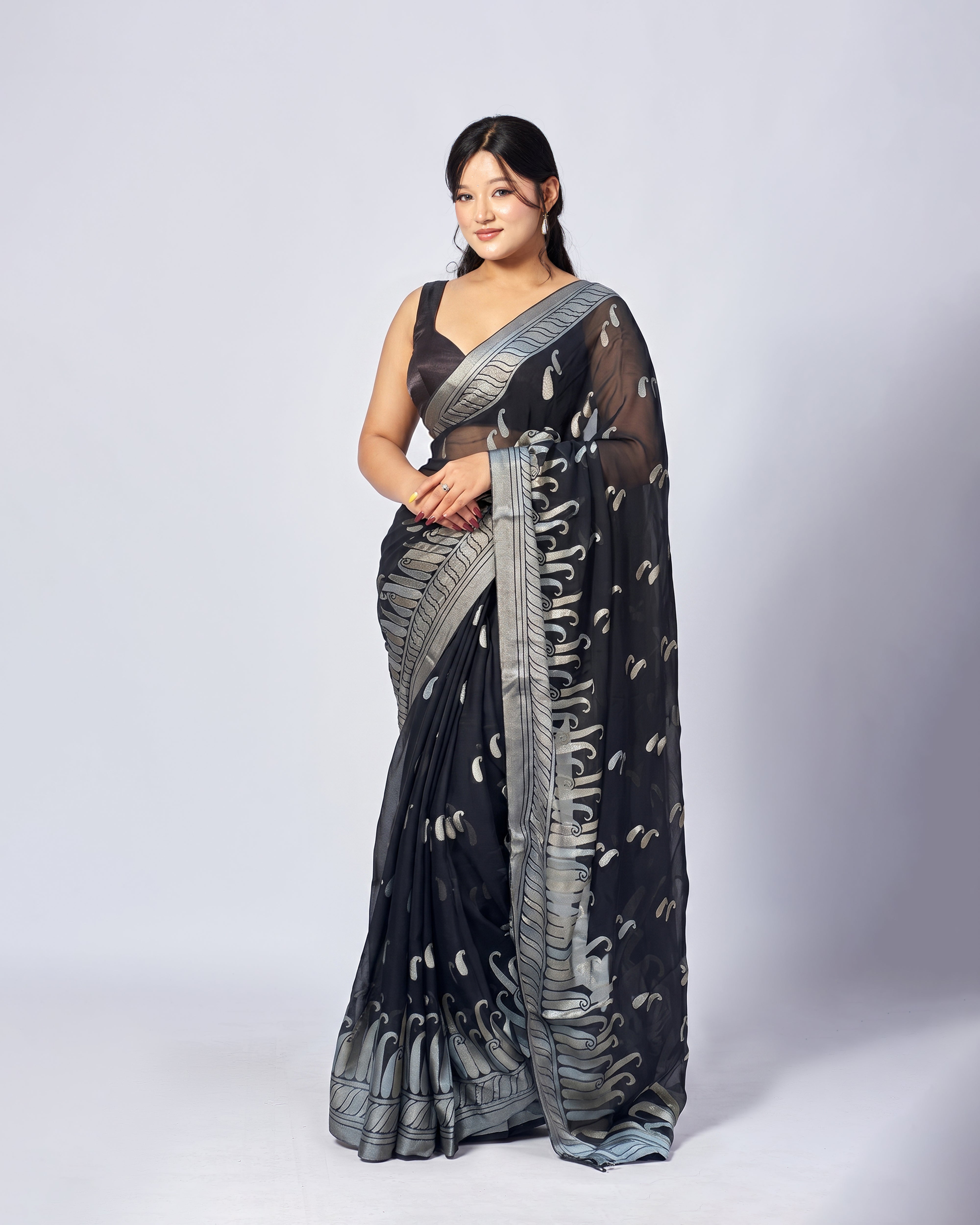 Woman wearing a black and silver saree on a white background