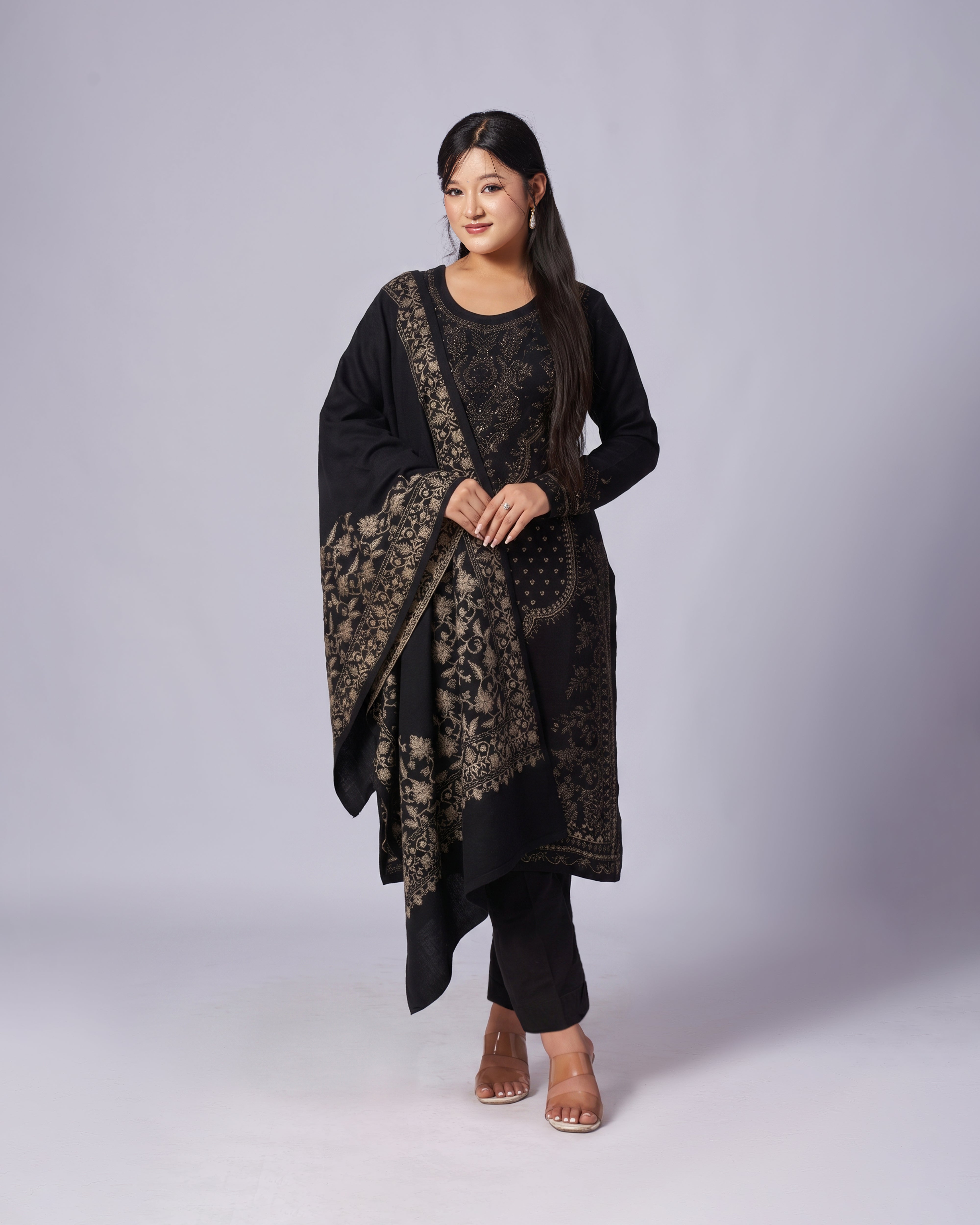 Woman wearing a black and gold traditional outfit on a white background