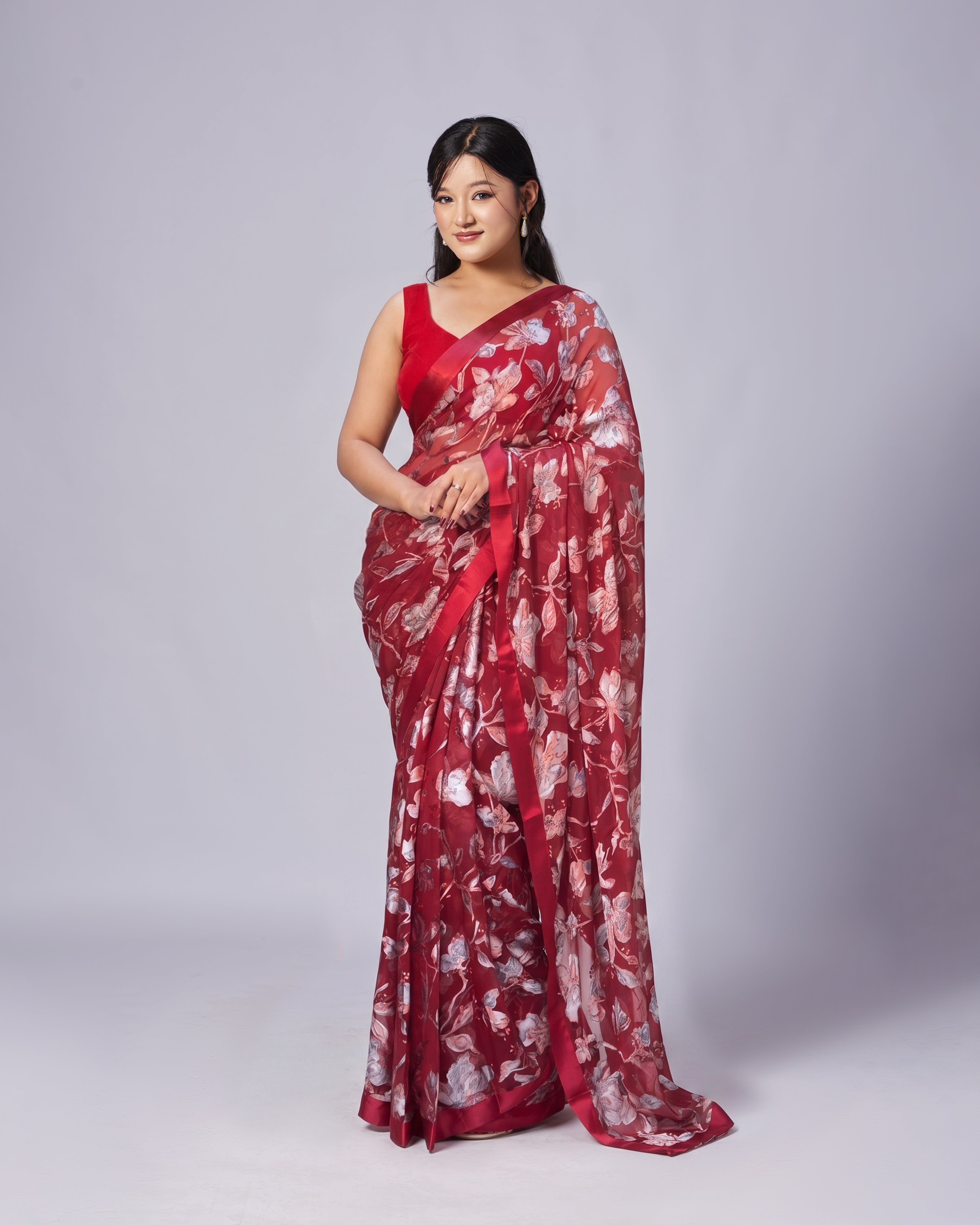 Woman wearing a red floral saree on a white background