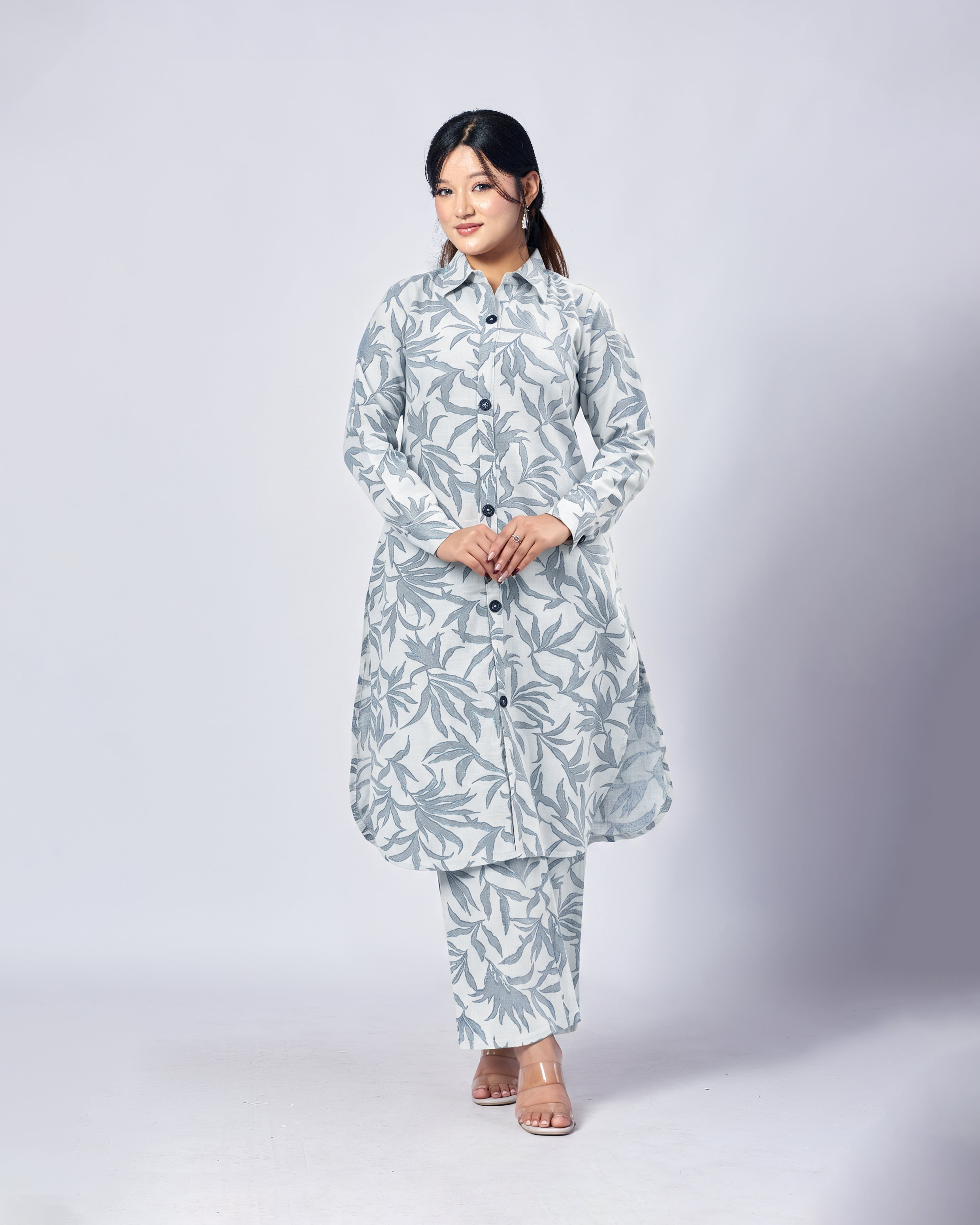 Woman wearing a light blue floral outfit on a white background
