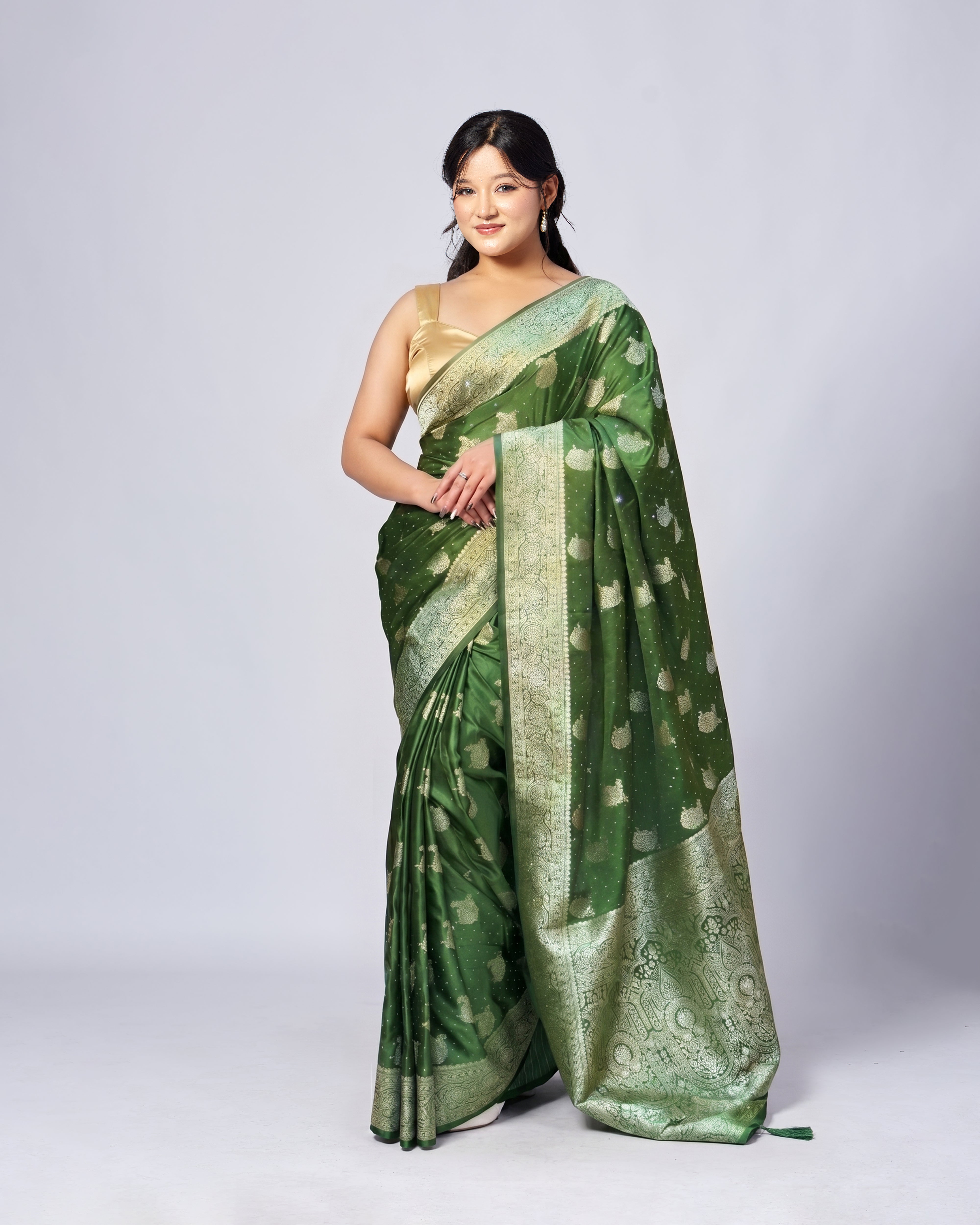 Woman wearing a green saree with a white pattern on a white background