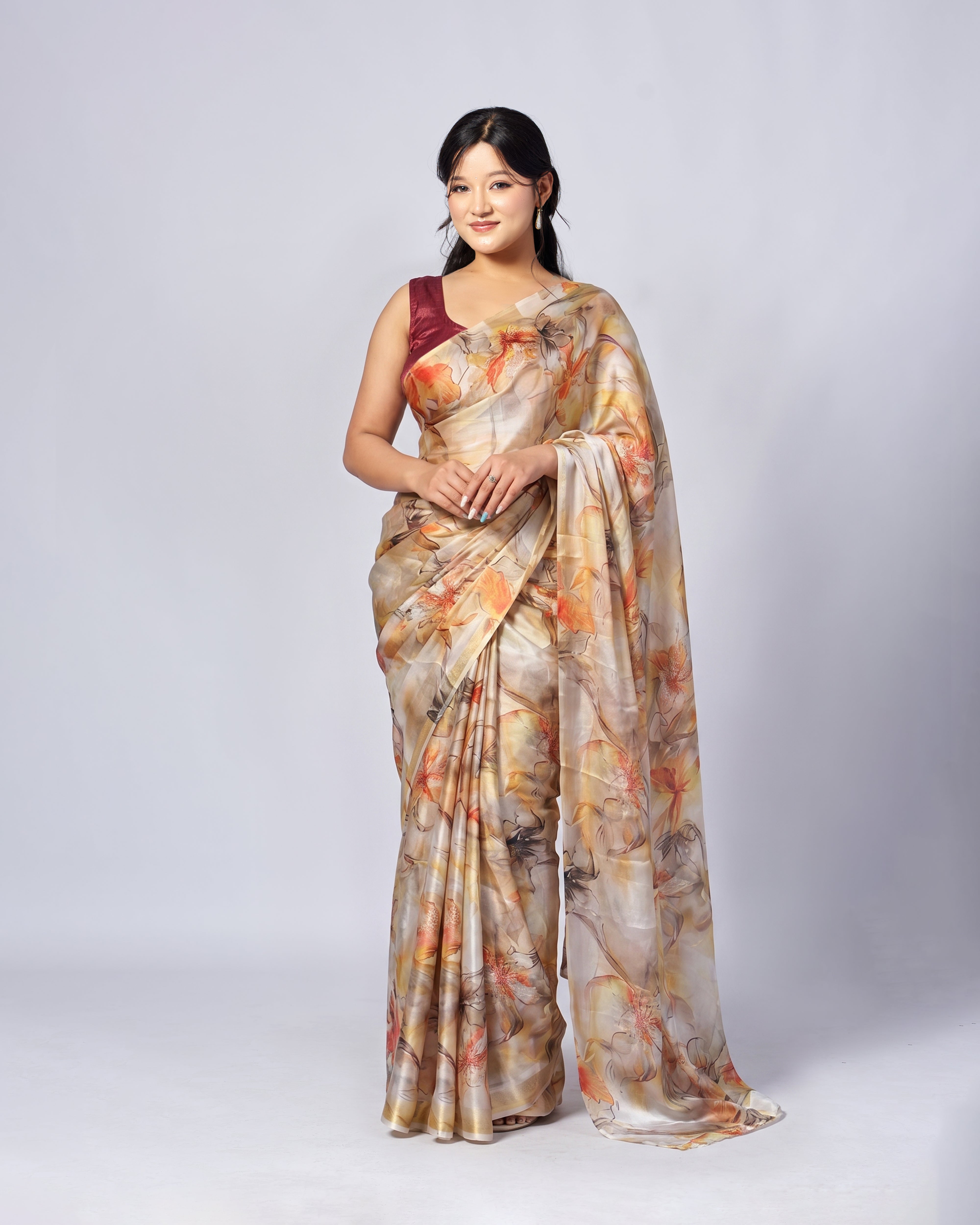 Woman wearing a floral saree with a plain background