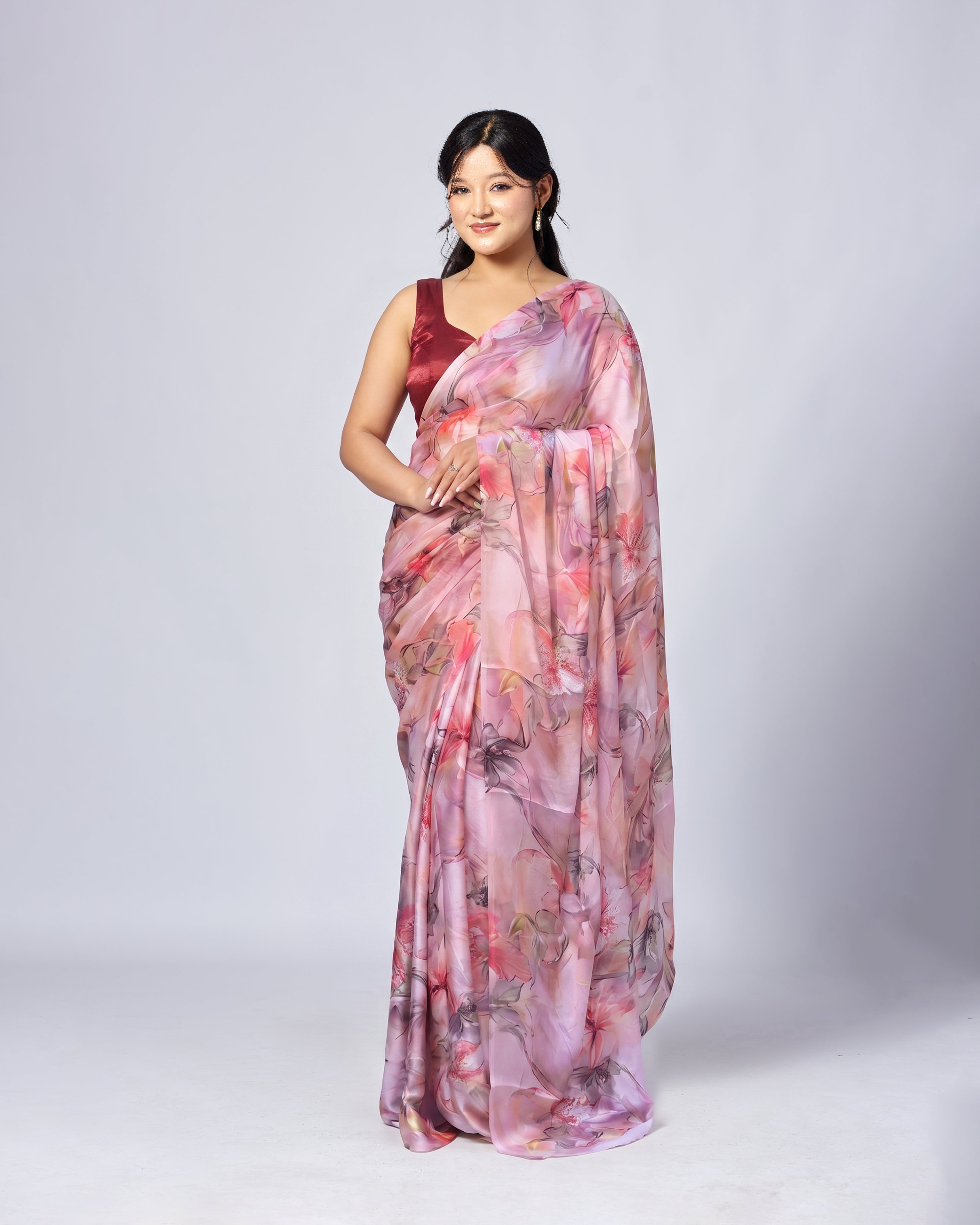 Woman wearing a floral saree with a plain background