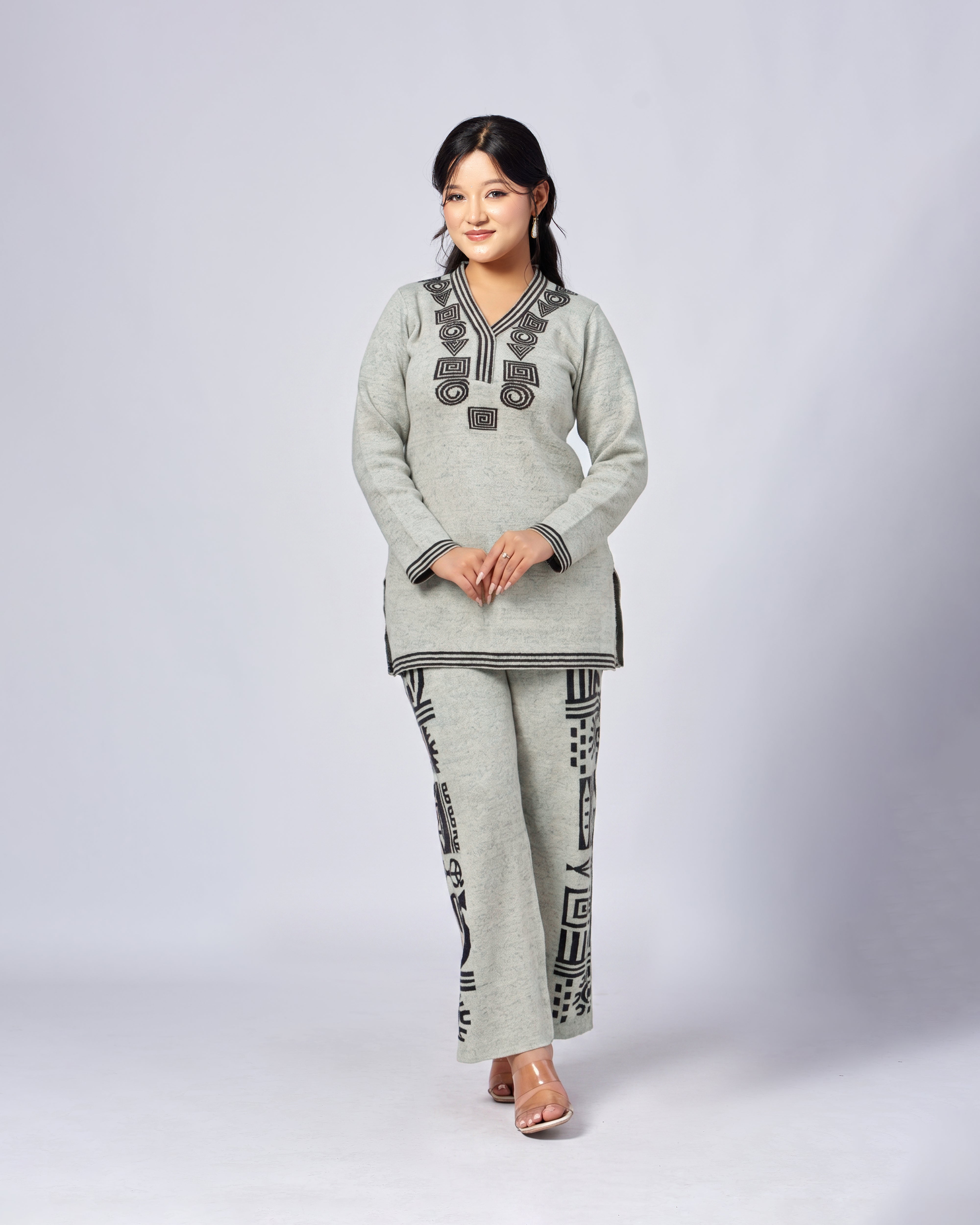 Woman wearing a gray outfit with black patterns on a white background