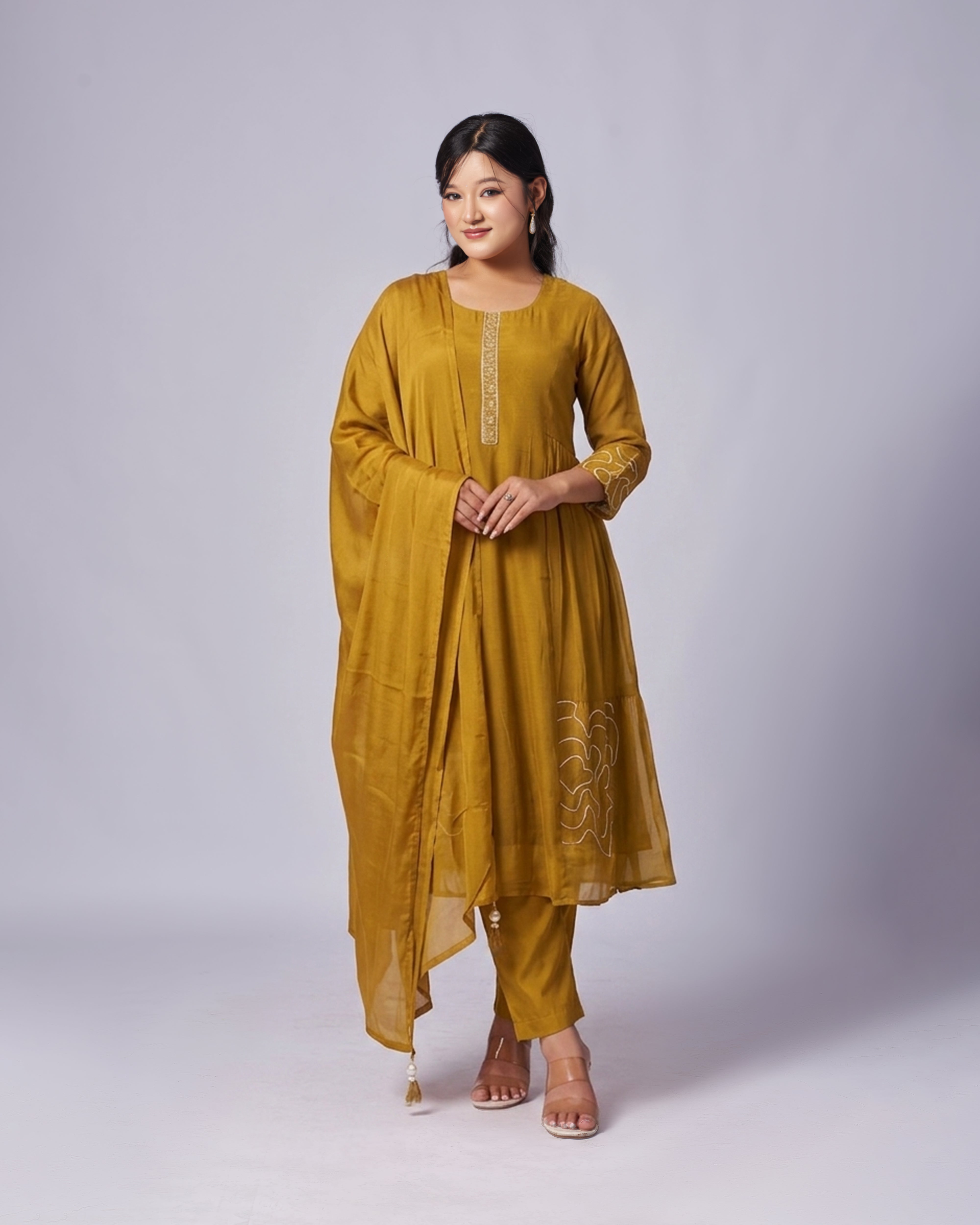 Woman wearing a mustard yellow traditional outfit on a white background