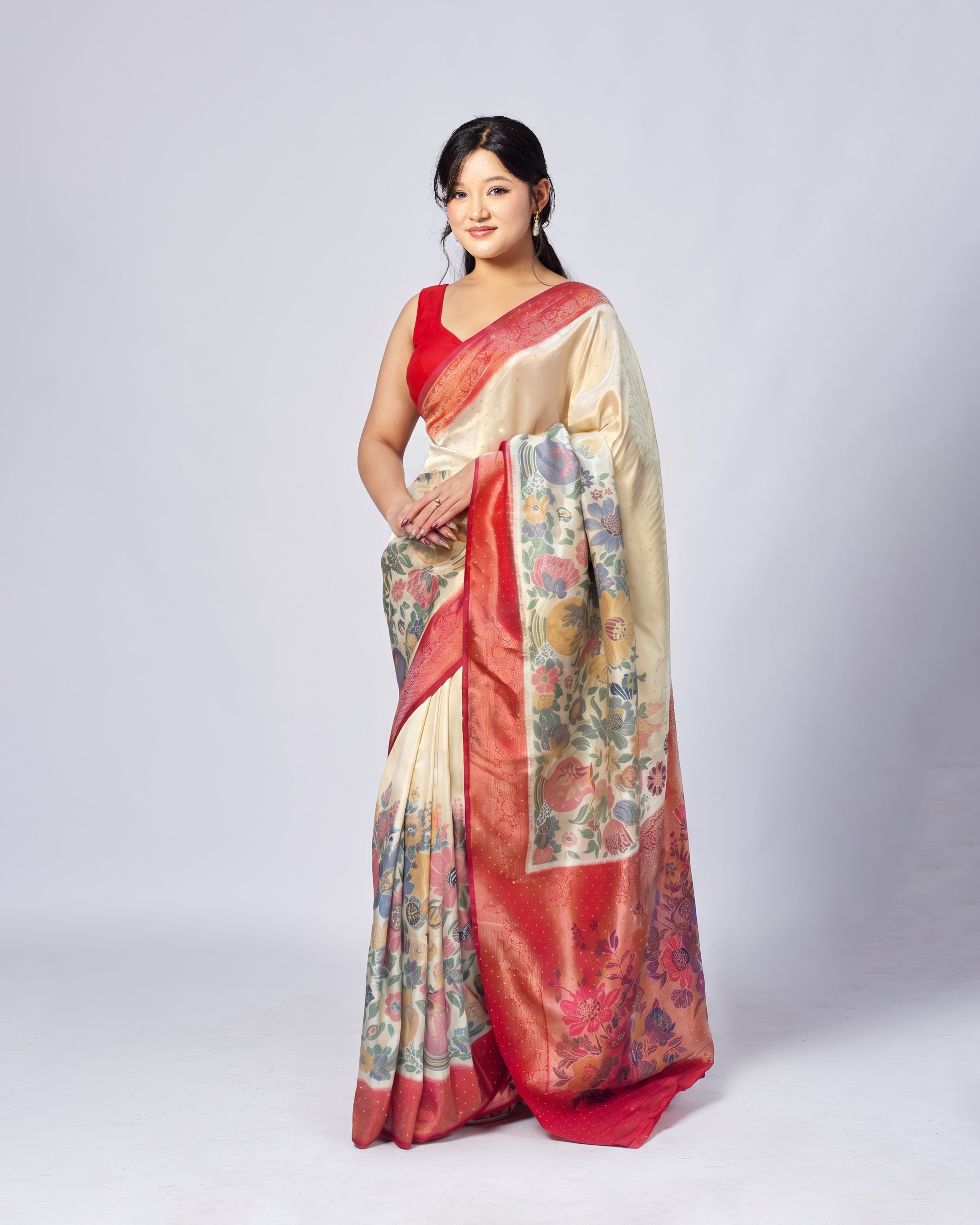 Woman wearing a traditional saree with a floral pattern on a plain background