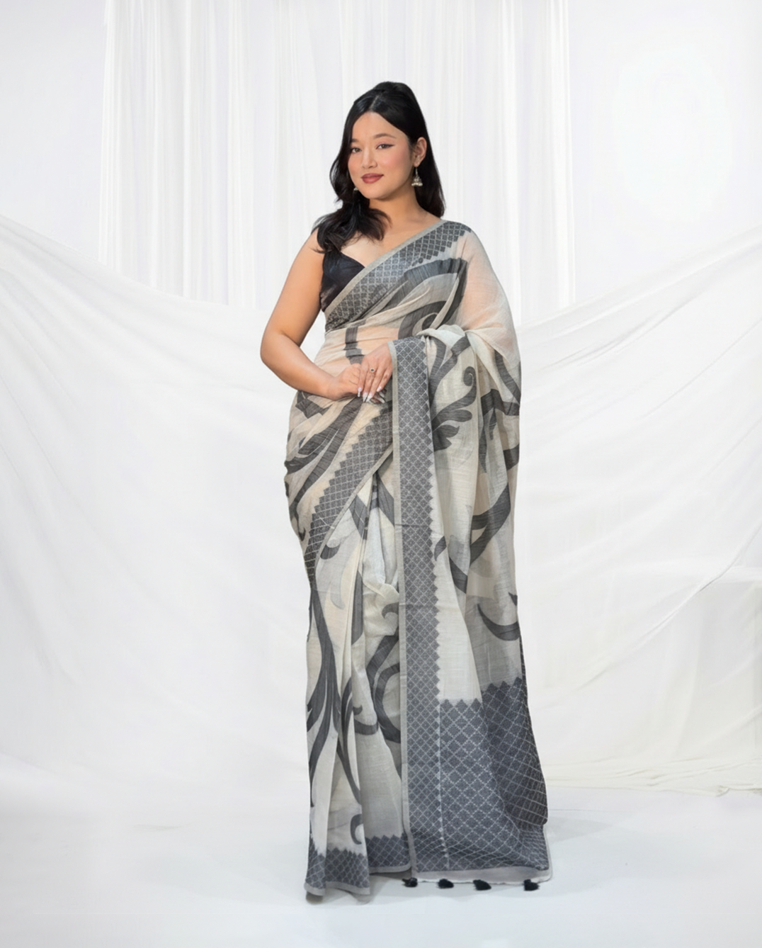 Woman wearing a patterned saree on a white background