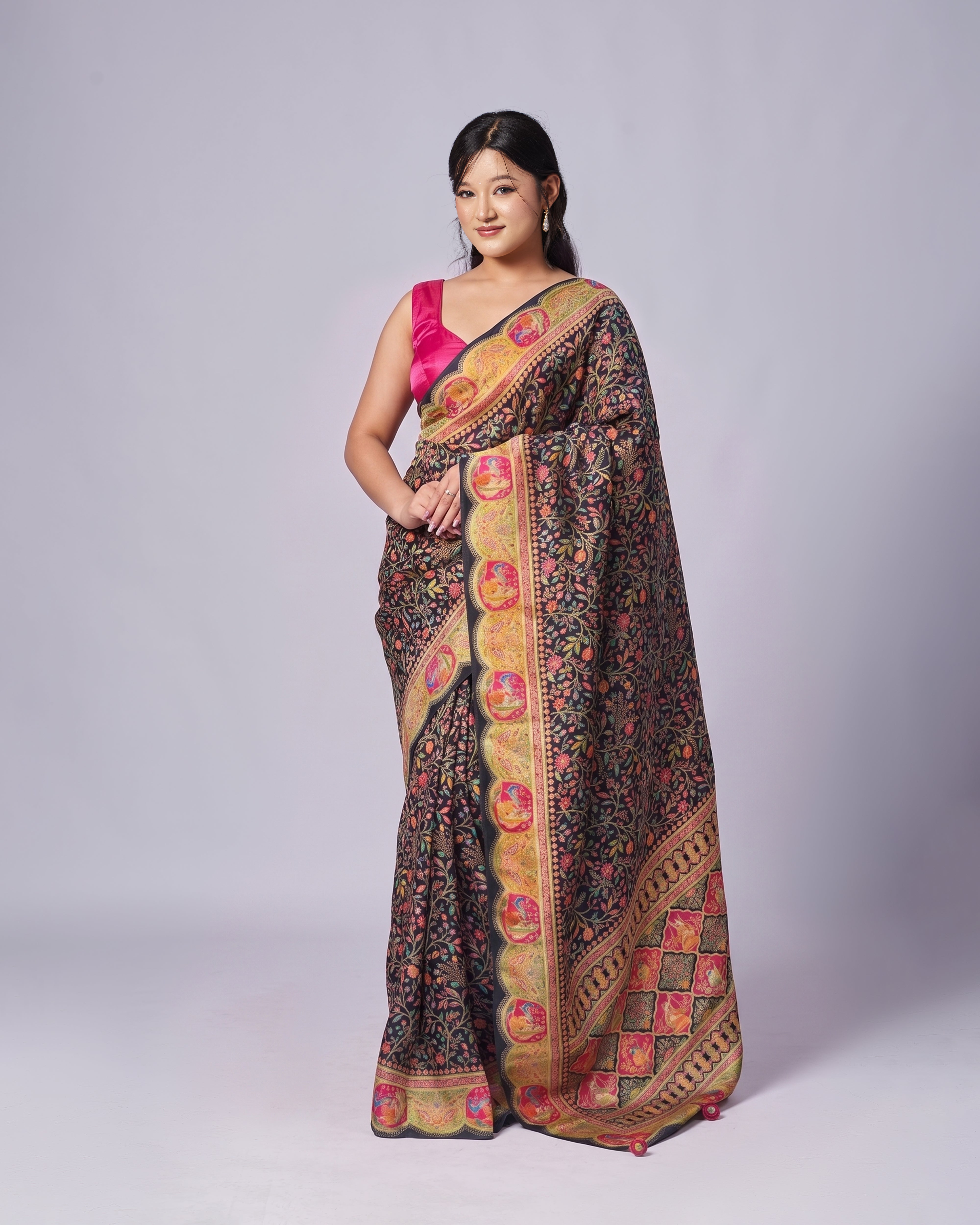 Woman wearing a traditional saree with a colorful pattern on a plain background