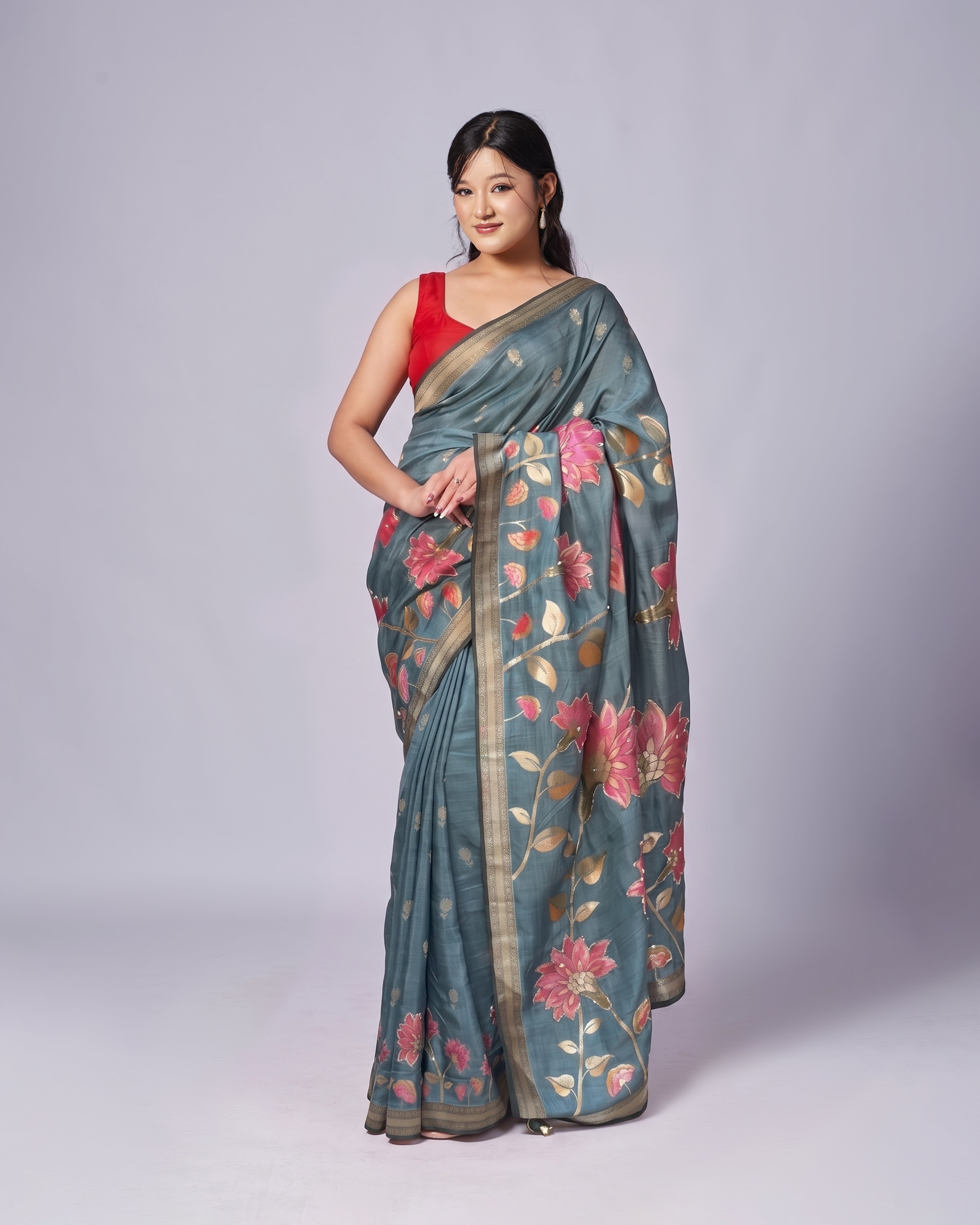 Woman wearing a floral saree with a plain background