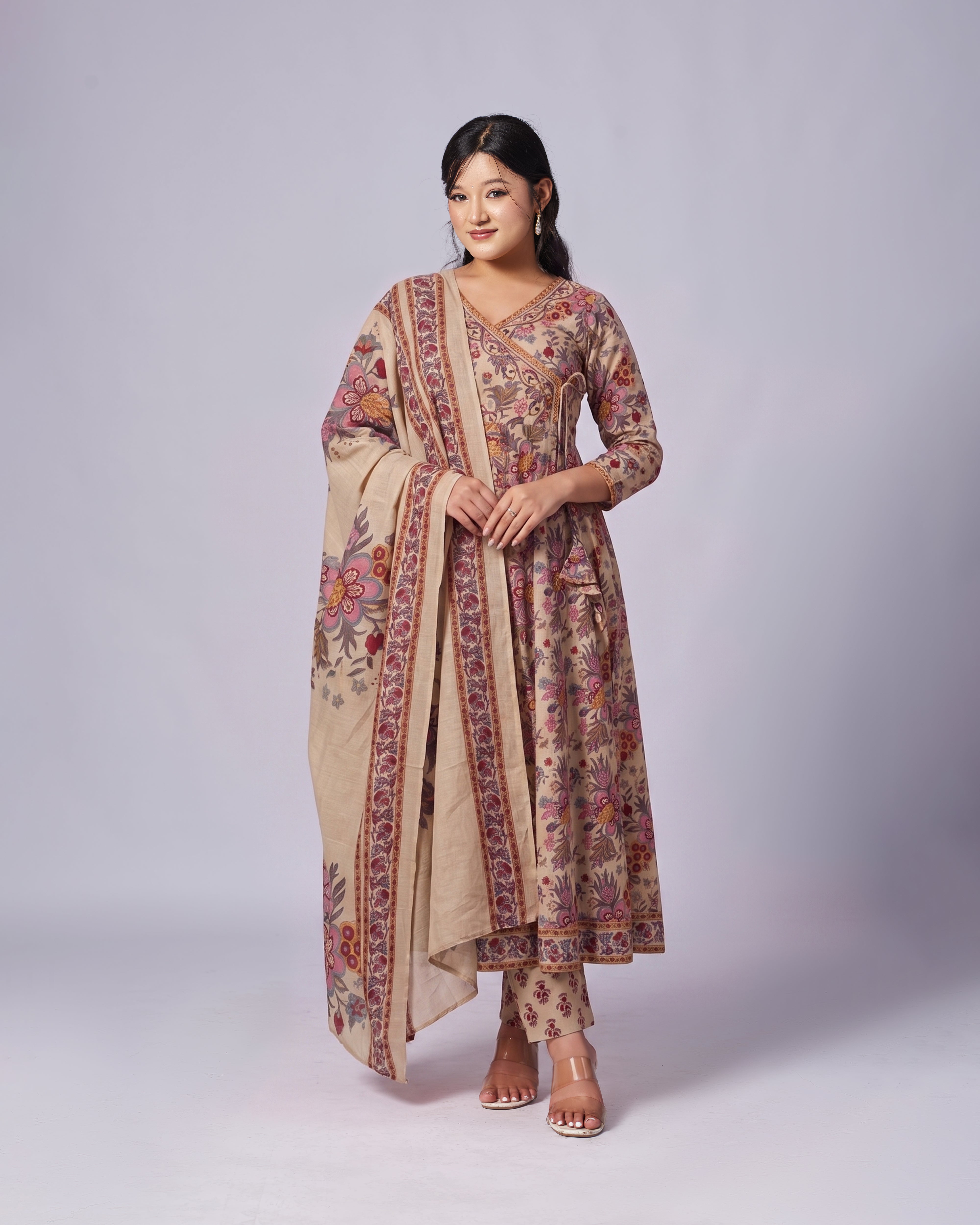 Woman wearing a traditional outfit with a floral pattern on a plain background