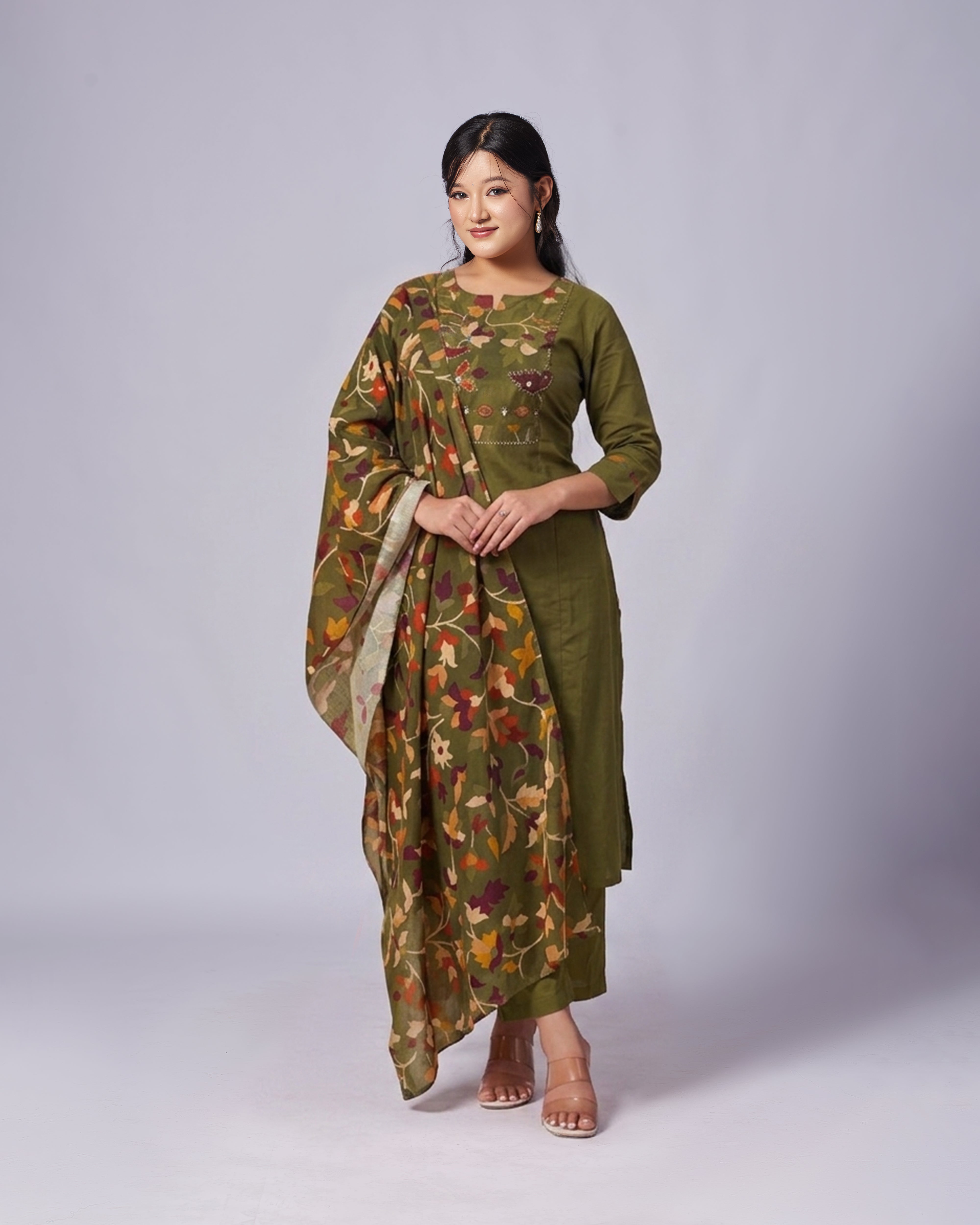 Woman wearing a green floral dress with a matching dupatta on a white background