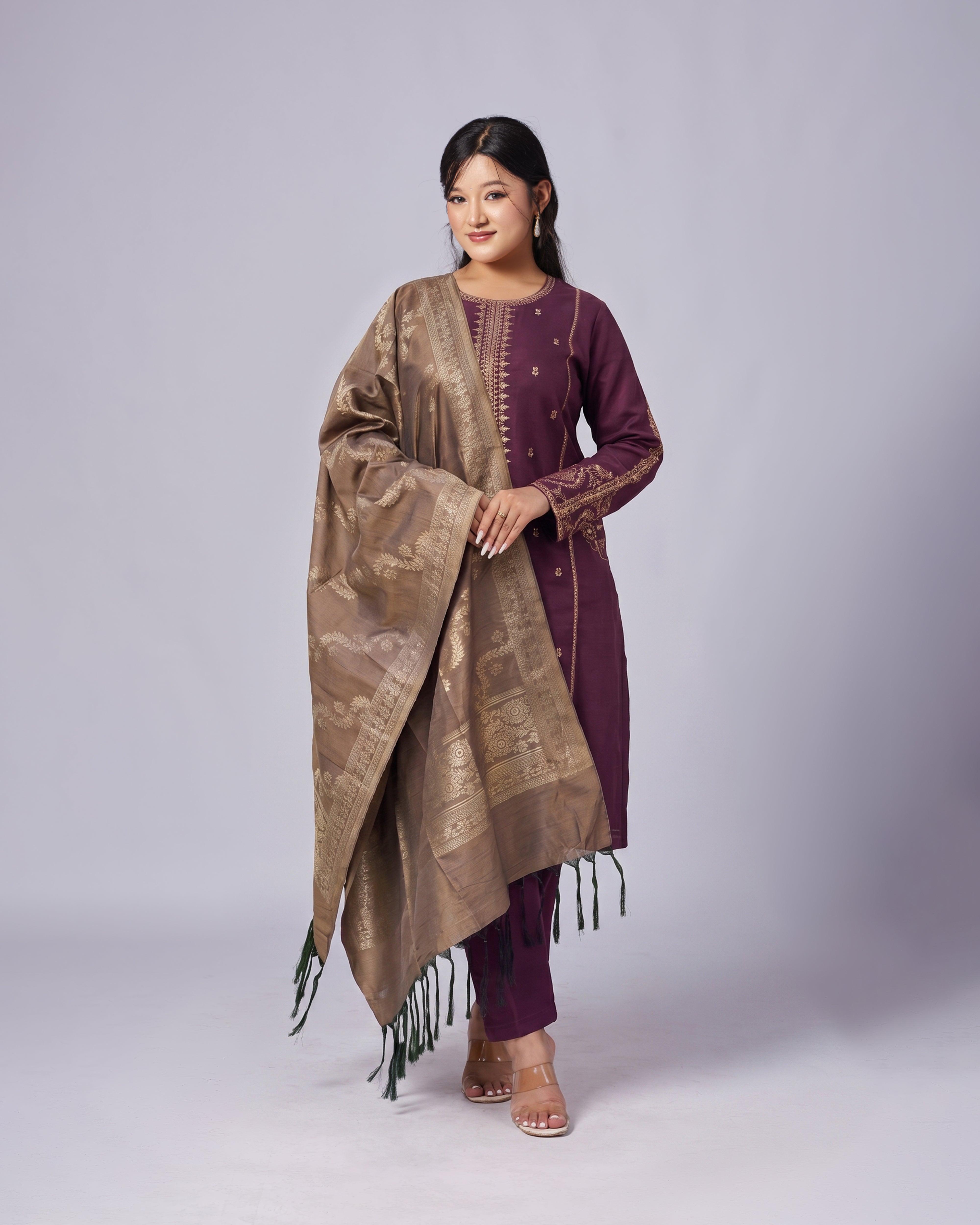 Woman wearing a traditional outfit with a brown dupatta and purple kurta on a white background