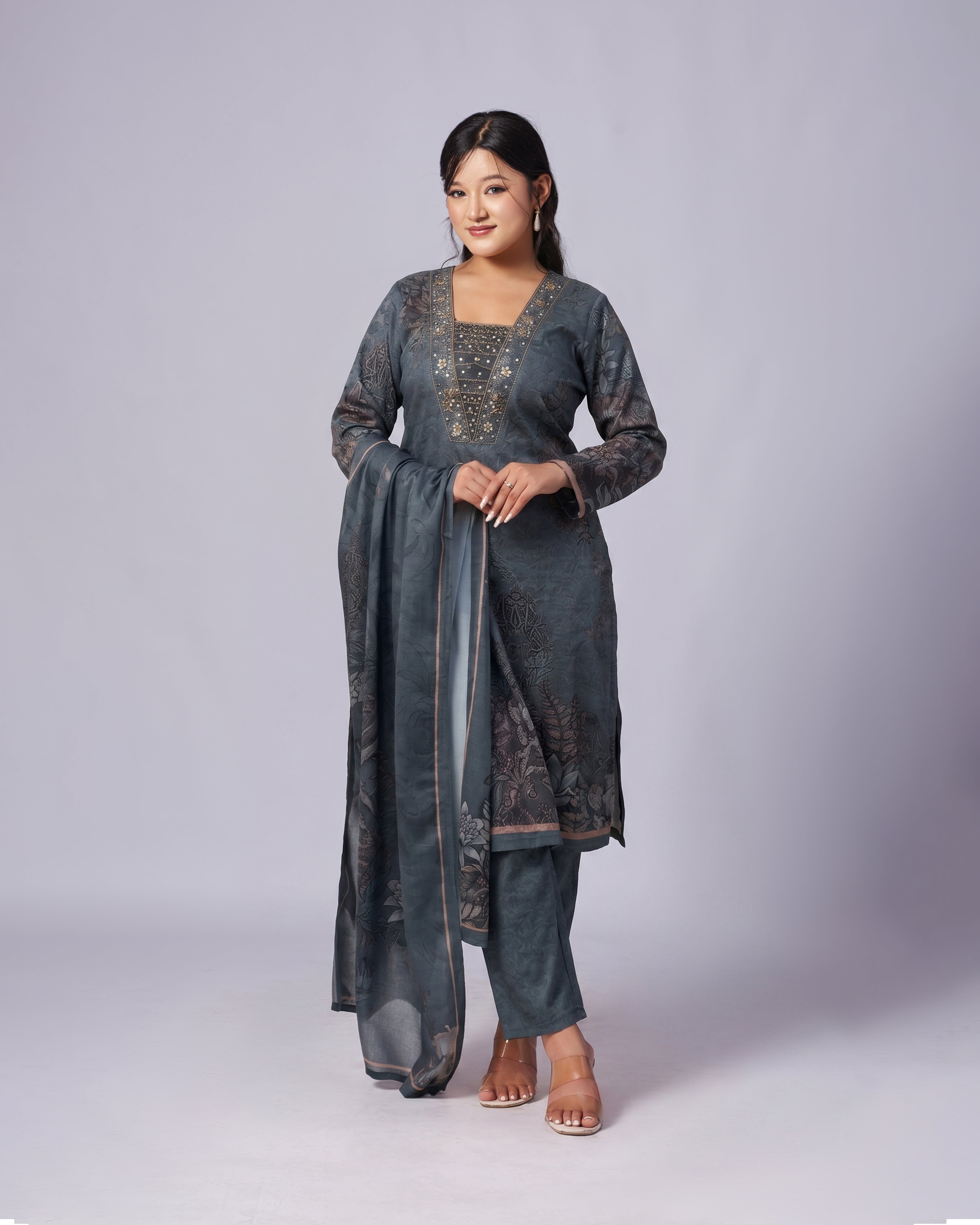 Woman wearing a gray traditional outfit with a plain background