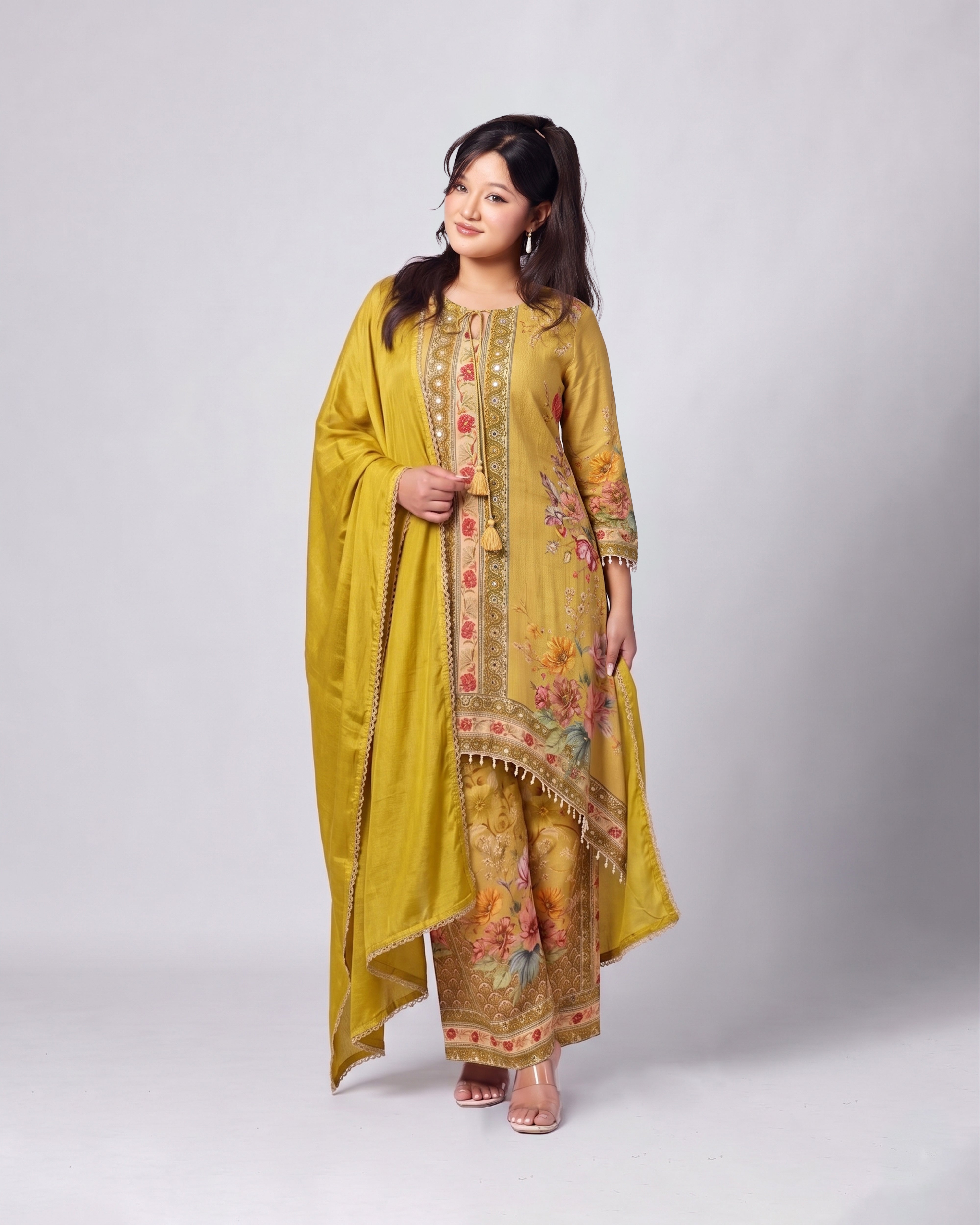 Woman wearing a yellow traditional outfit with floral patterns on a white background