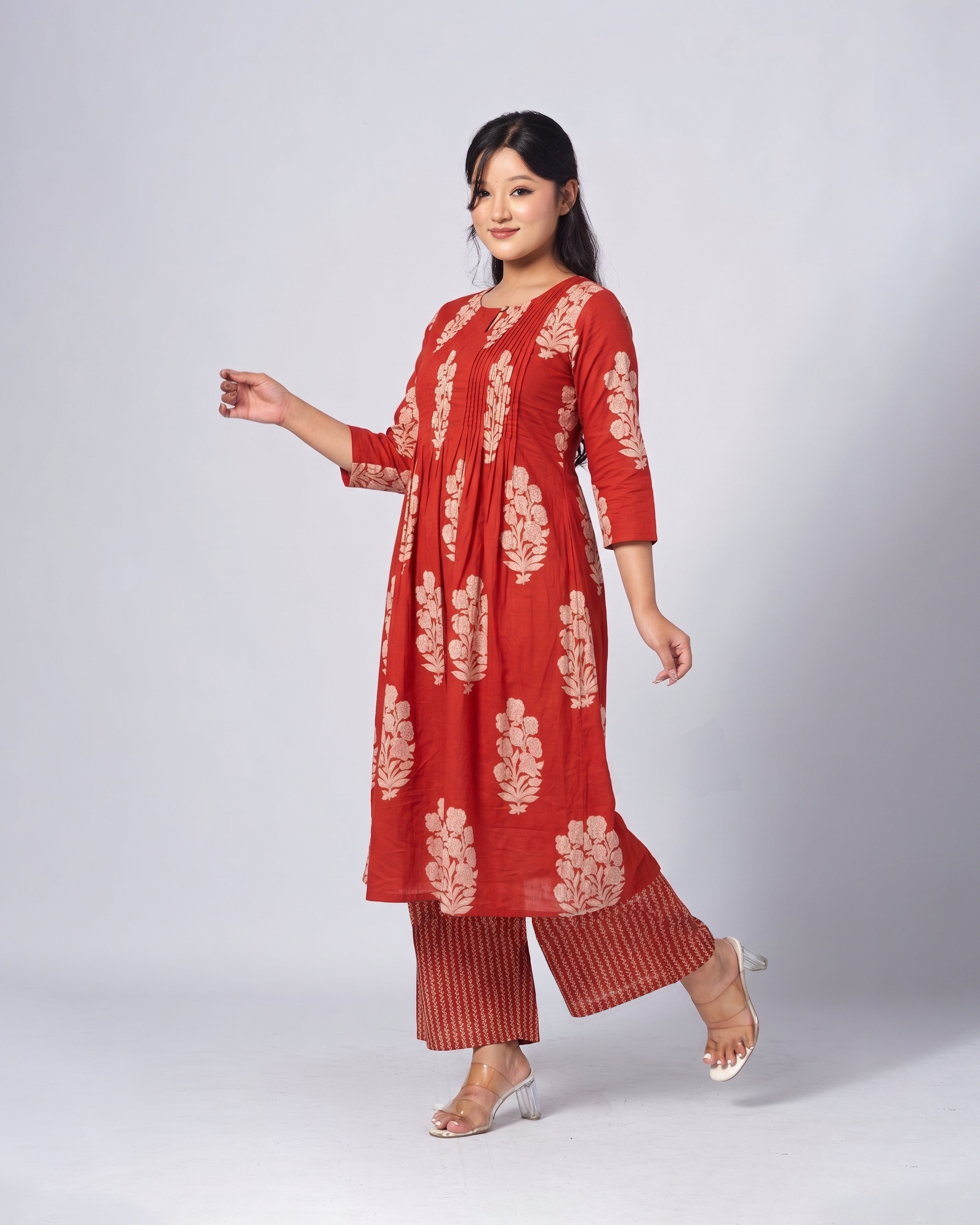 Woman wearing a red embroidered outfit on a white background