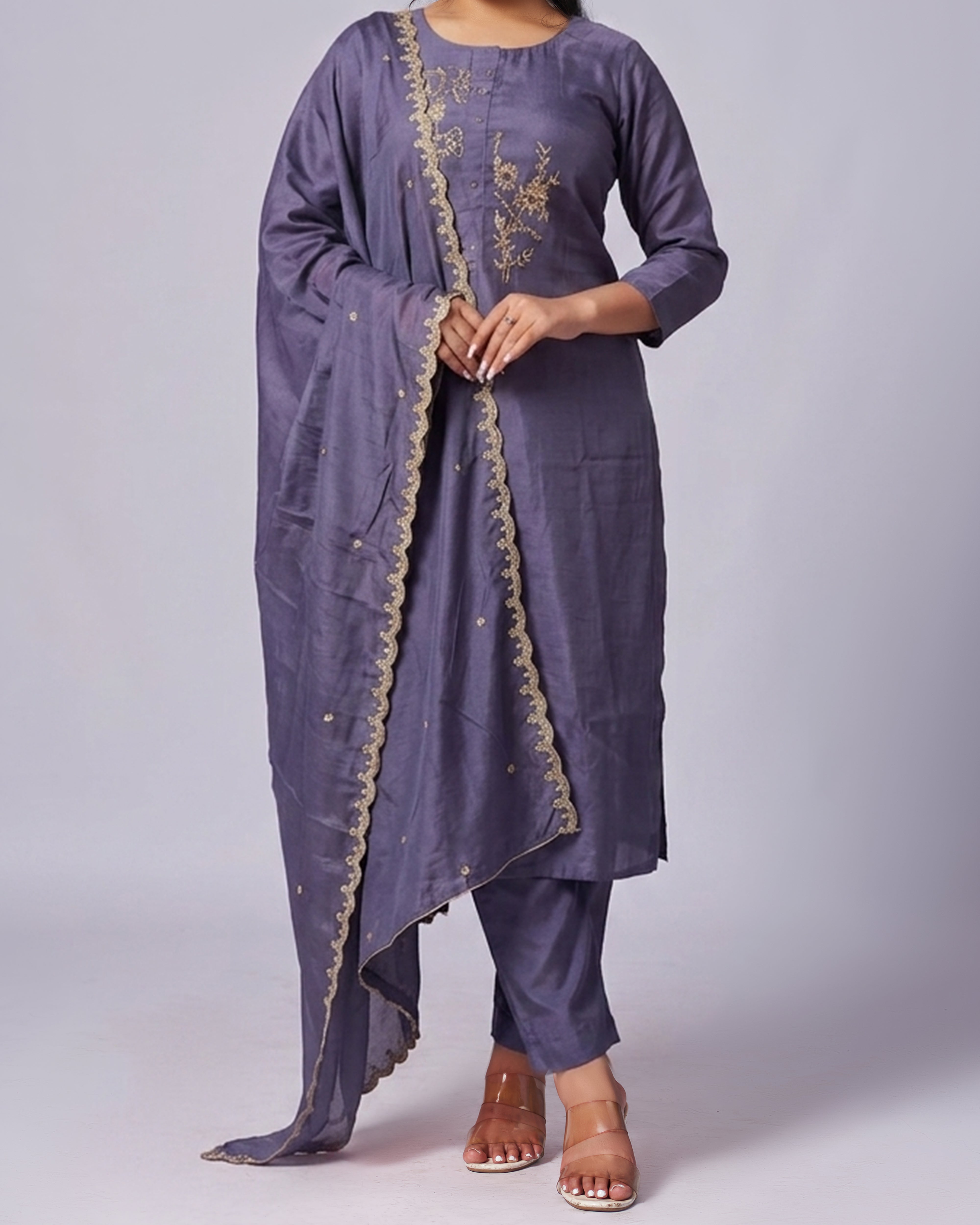 Purple traditional outfit with gold embroidery on a plain background