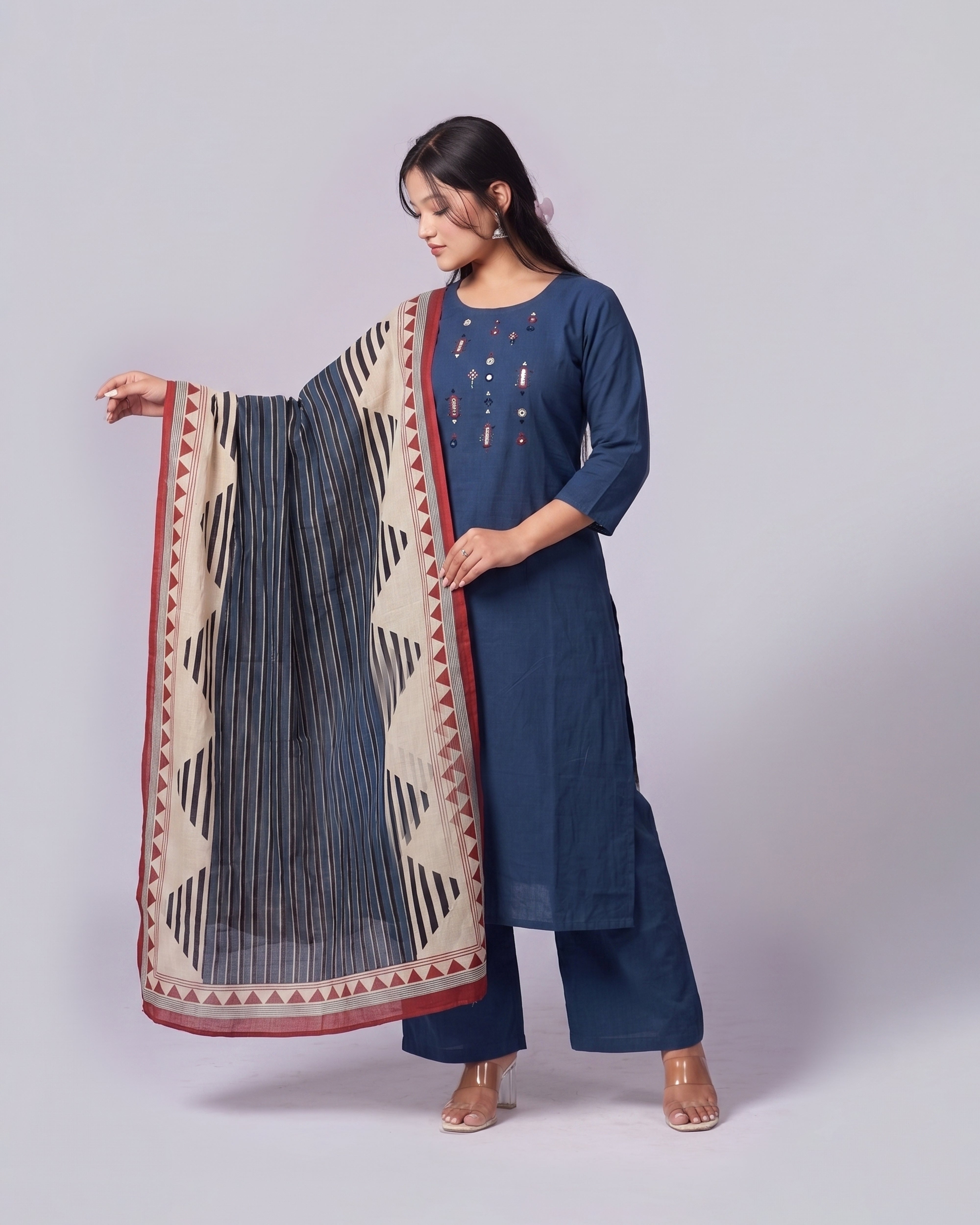 Woman wearing a blue kurta with a patterned dupatta on a light gray background
