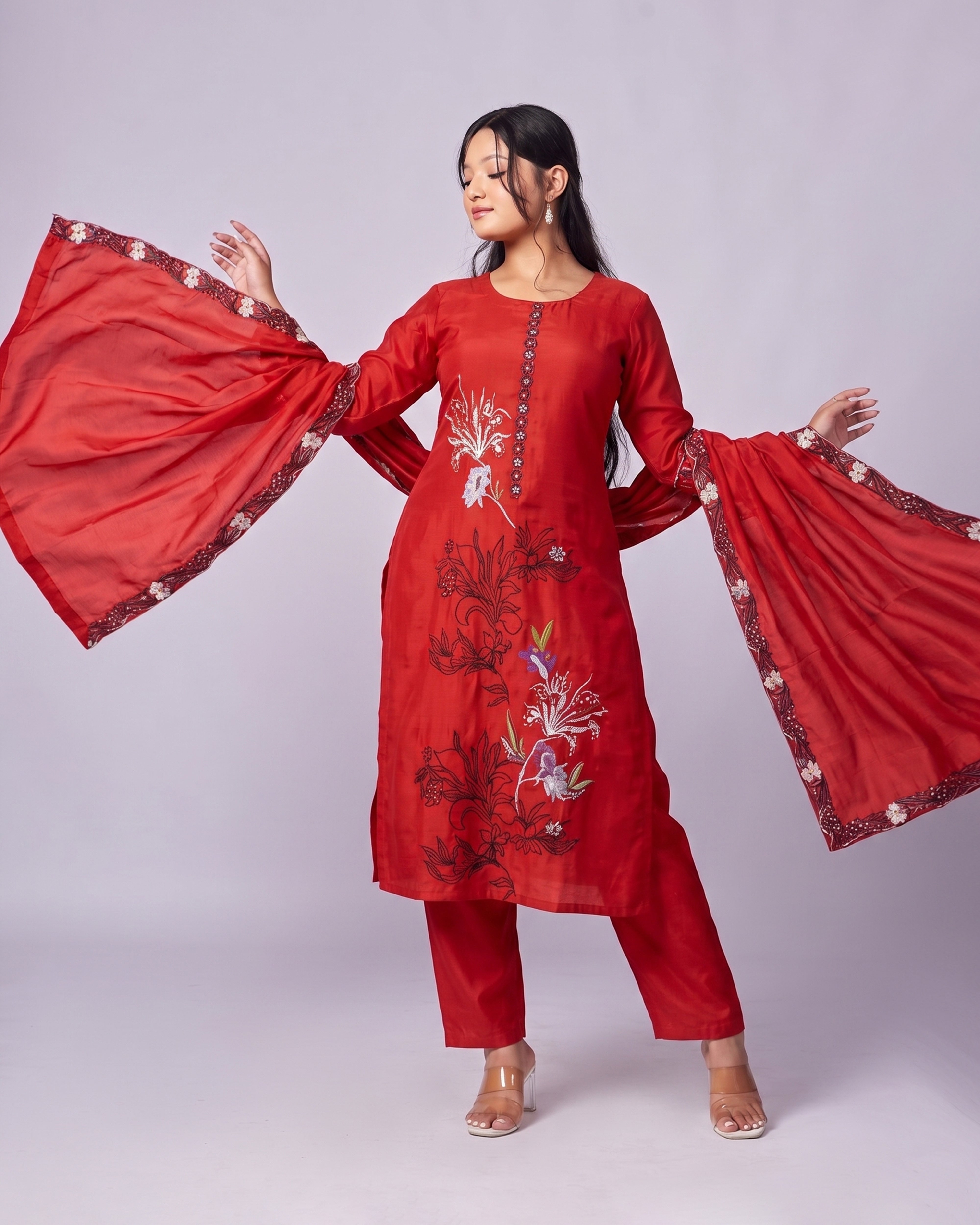Woman wearing a red embroidered traditional outfit with a grey  background