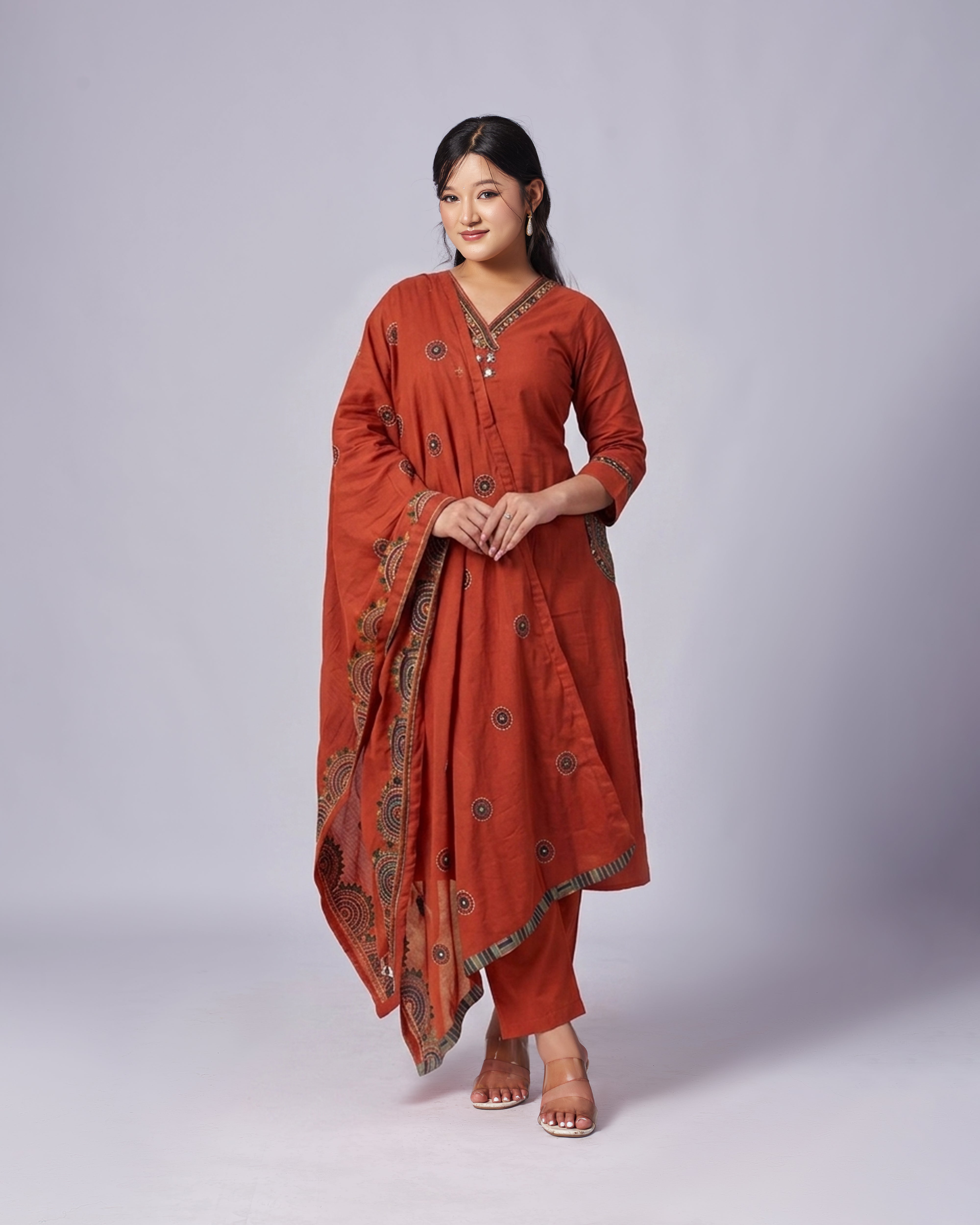 Woman wearing a traditional red outfit with a matching dupatta on a white background