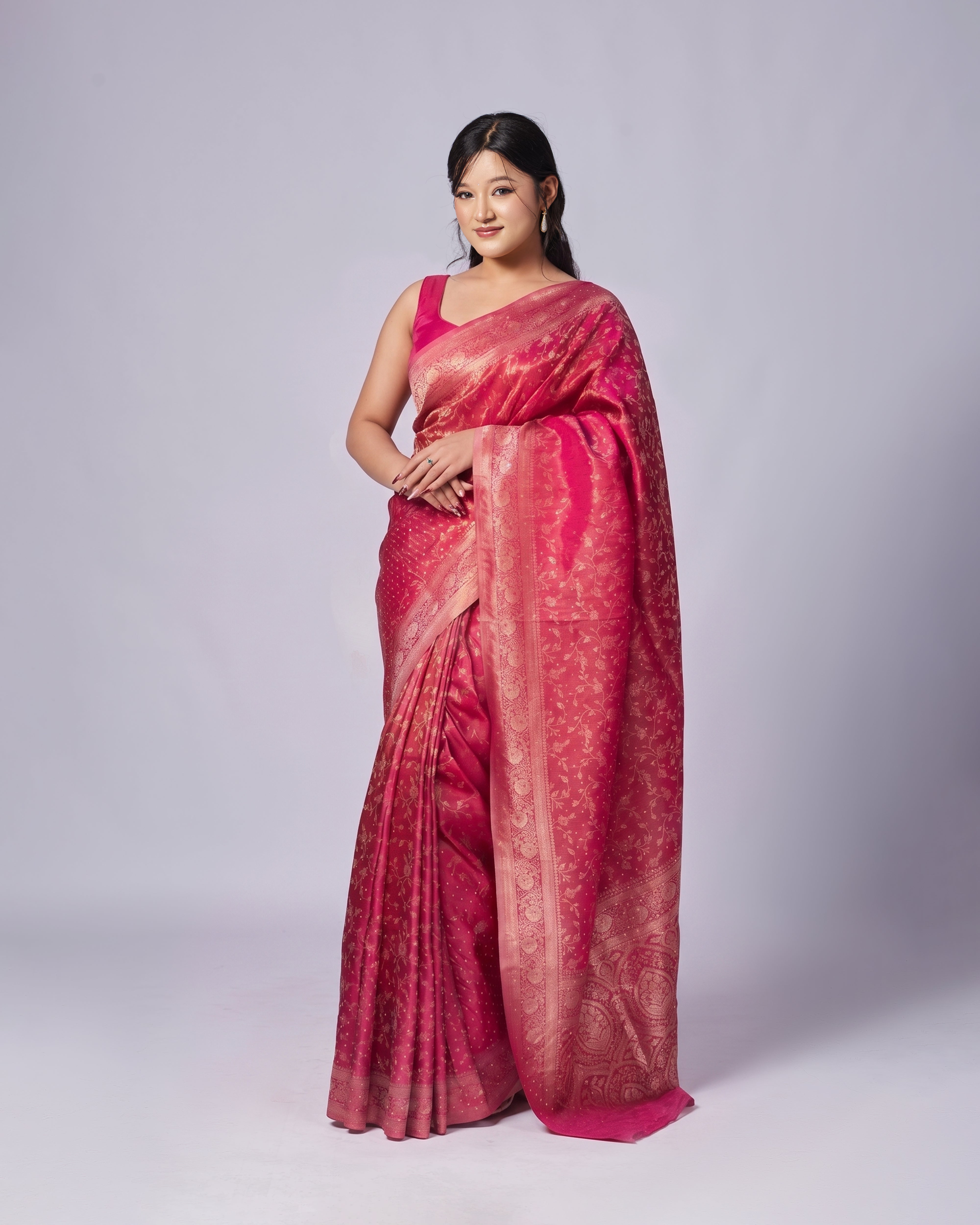 Woman wearing a pink saree on a white background