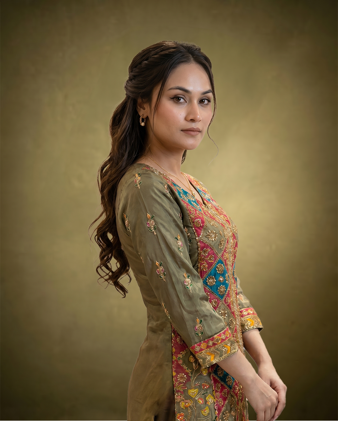 Woman wearing a traditional embroidered outfit against a brown background