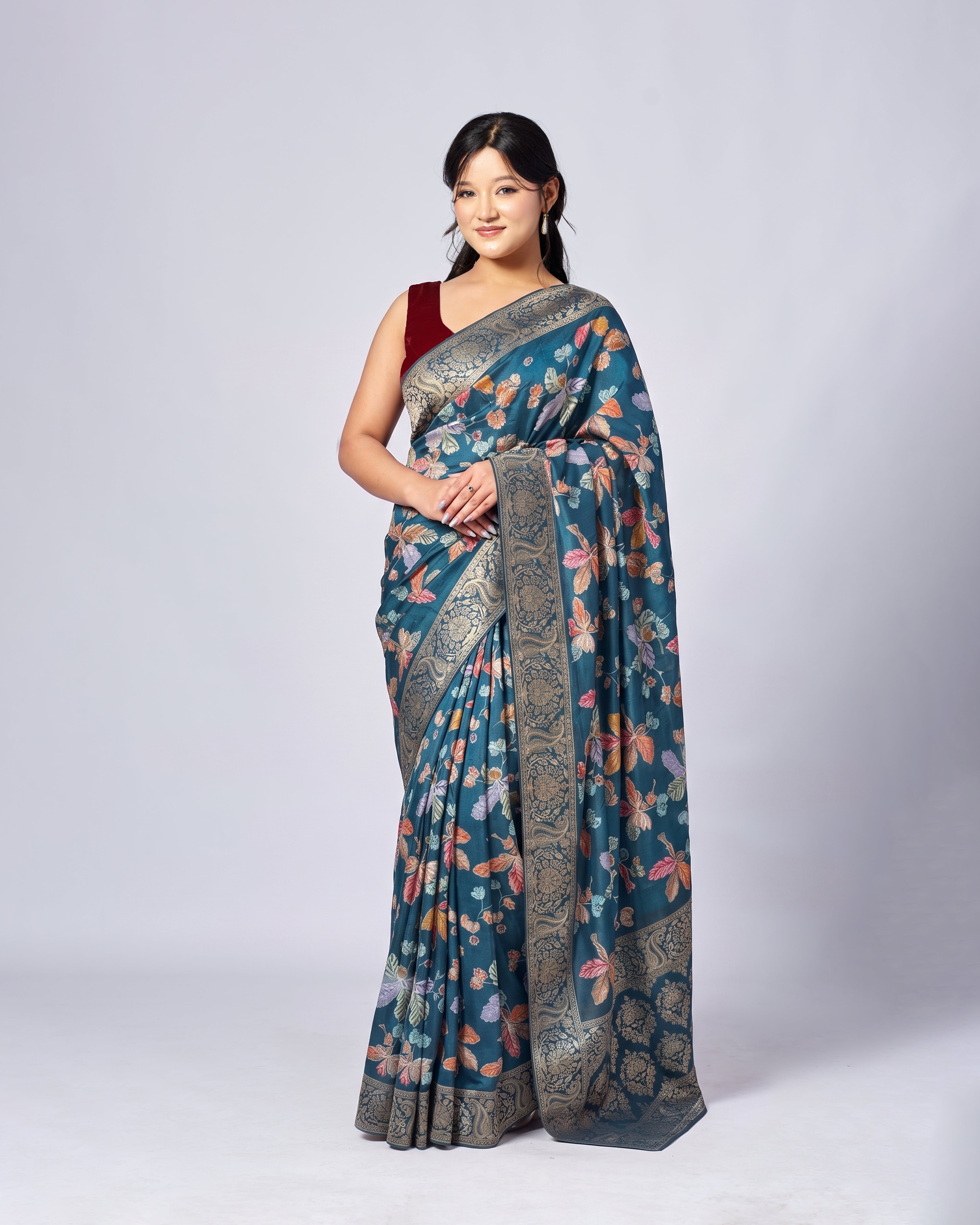 Woman wearing a blue floral saree with a white background