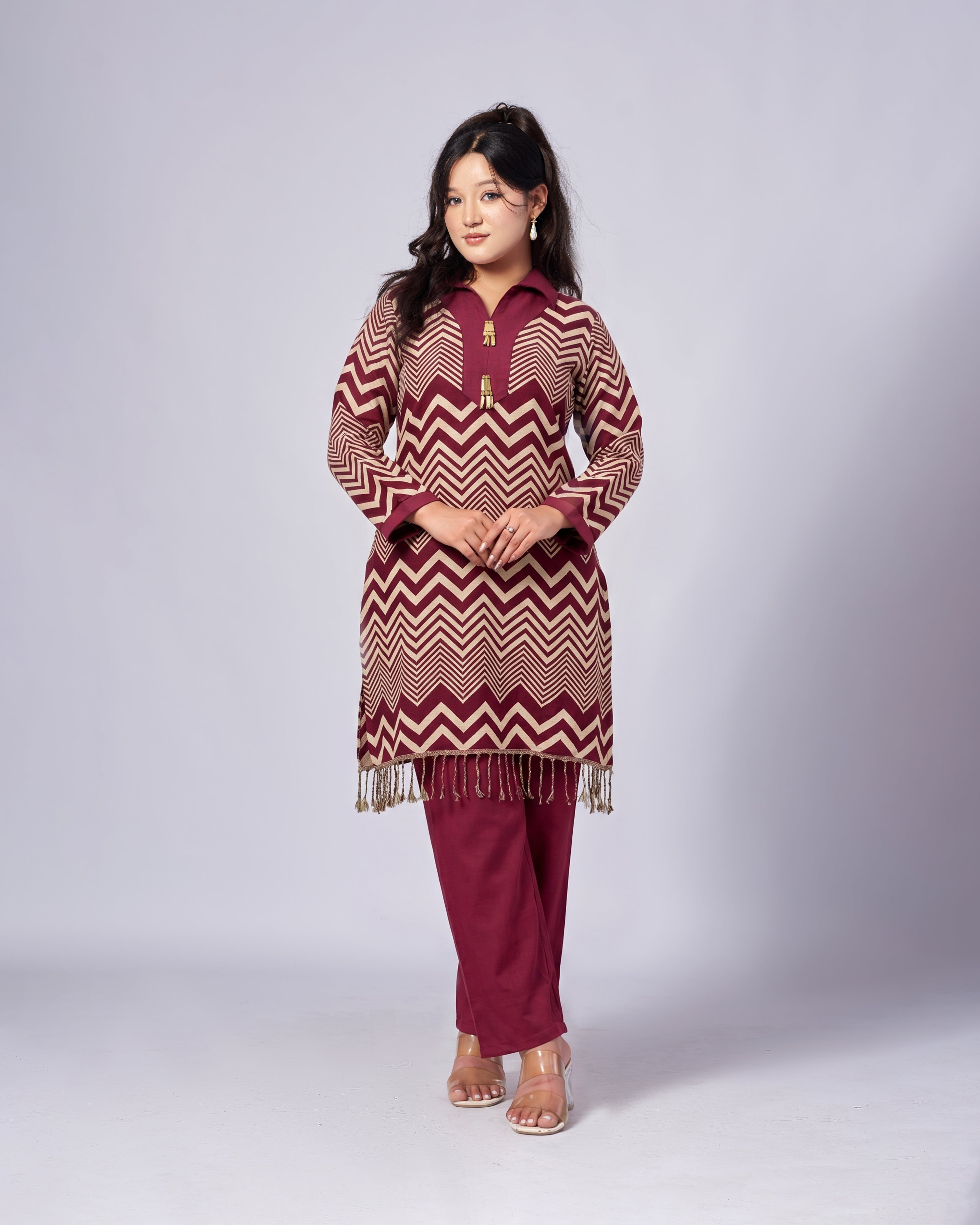 Woman wearing a patterned kurta with fringes on a white background