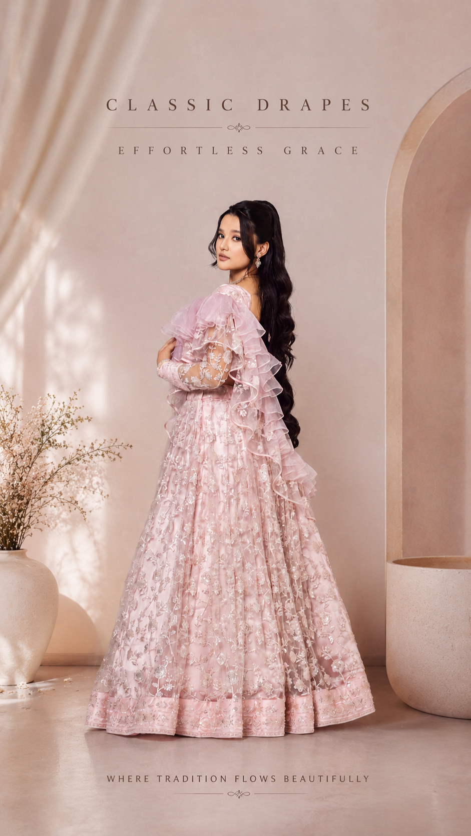 Woman in a pink traditional outfit with floral details standing in a softly lit room.