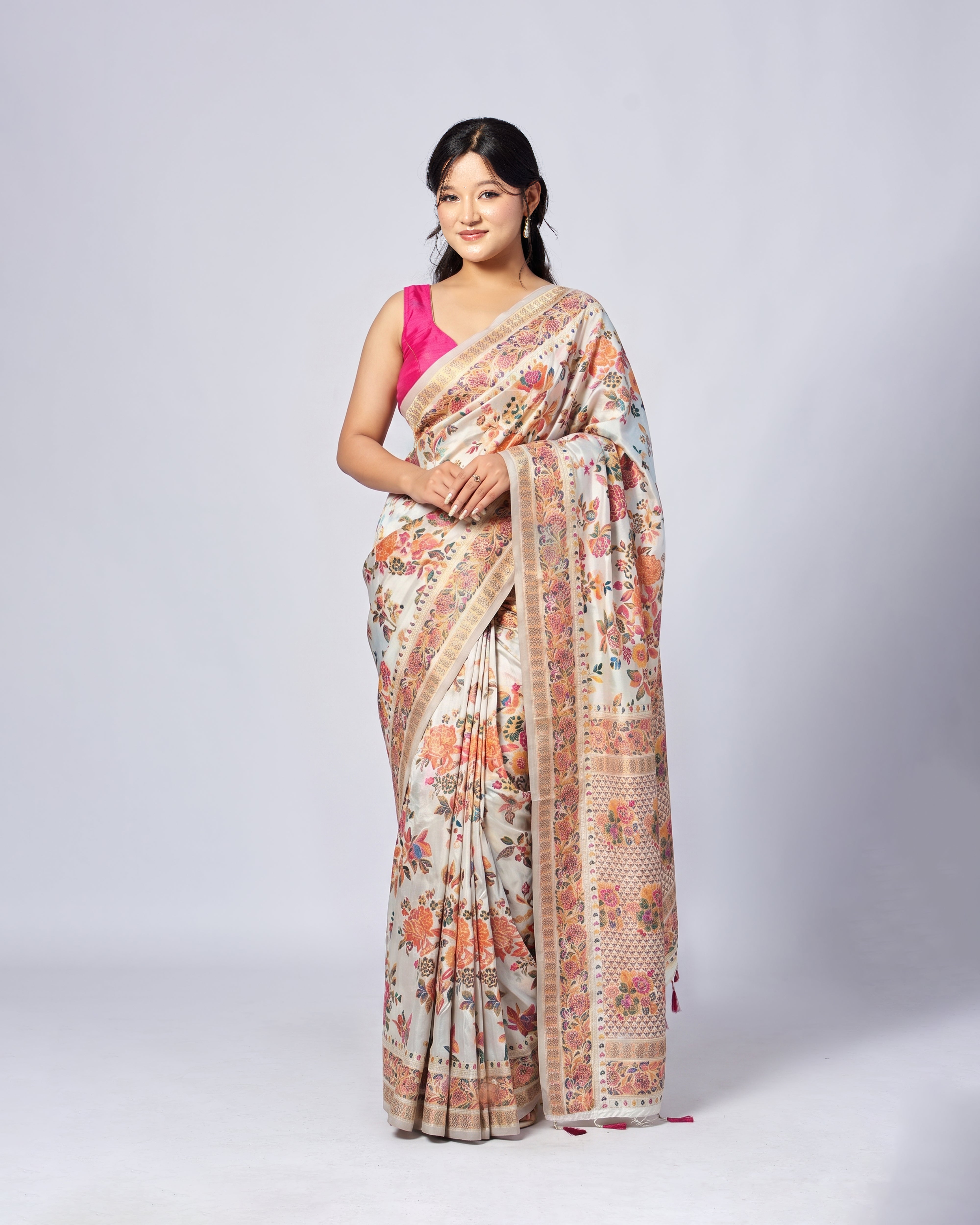 Woman wearing a floral saree with a pink blouse on a white background