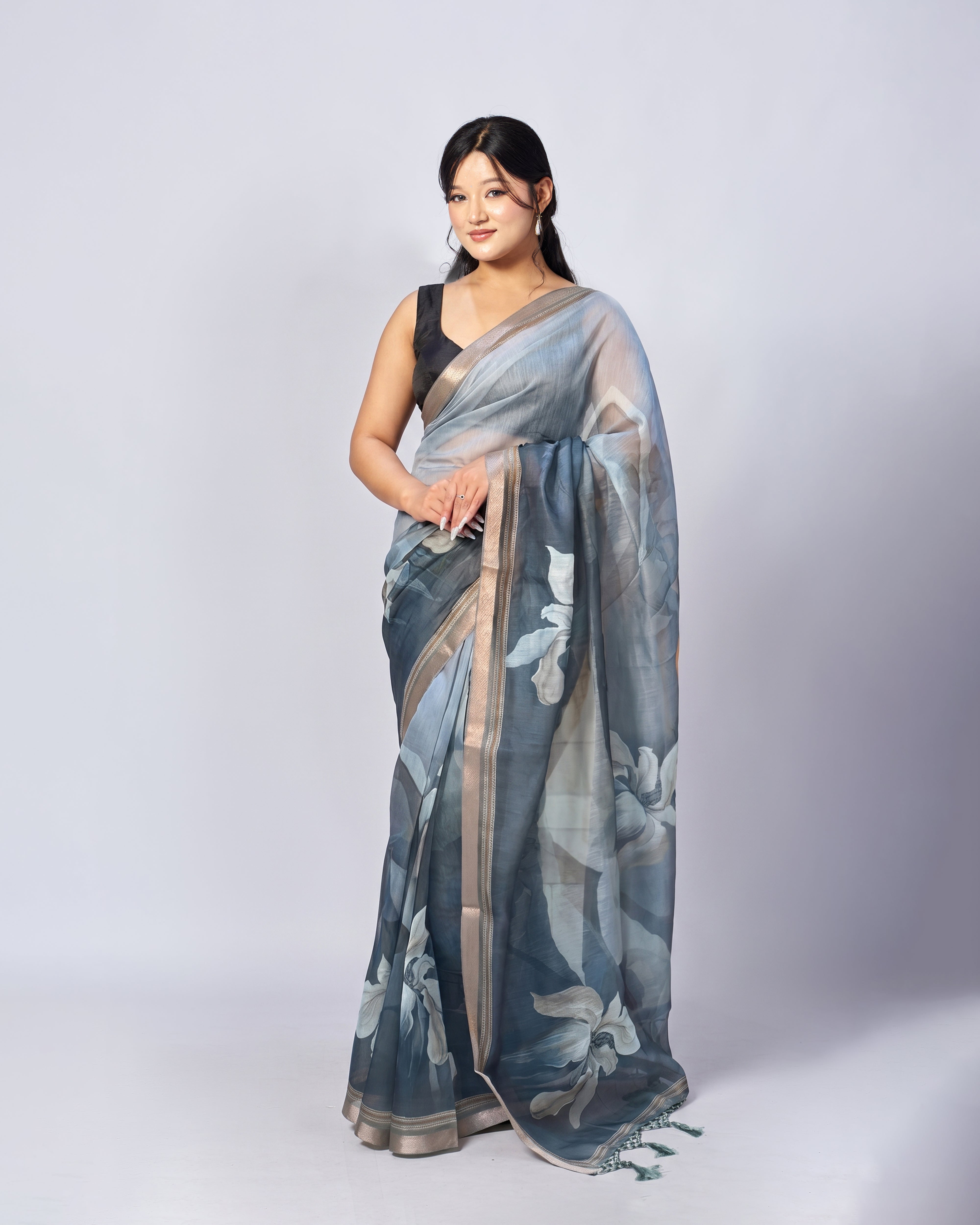Woman wearing a floral saree on a plain background