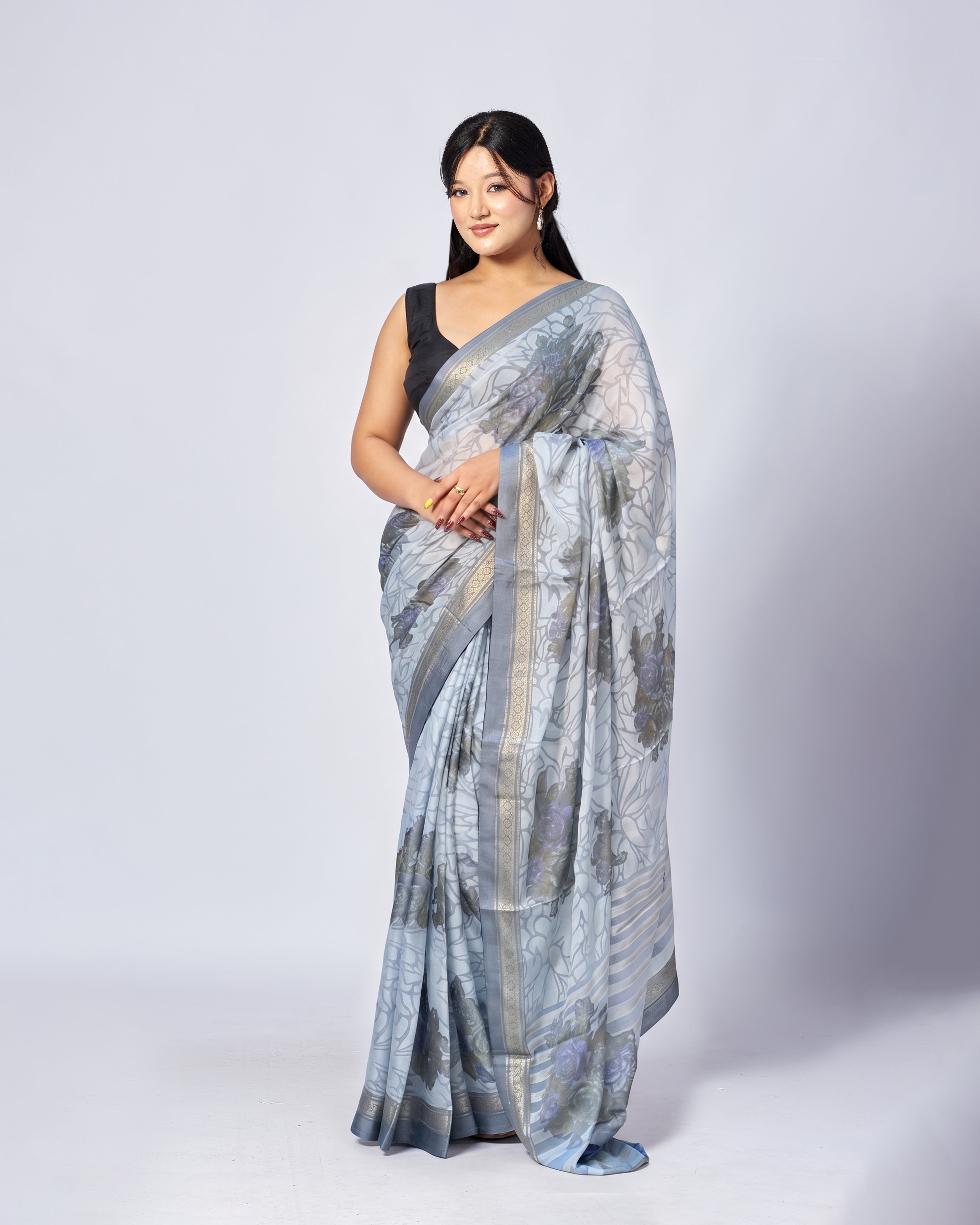 Woman wearing a blue and gray saree with a white background