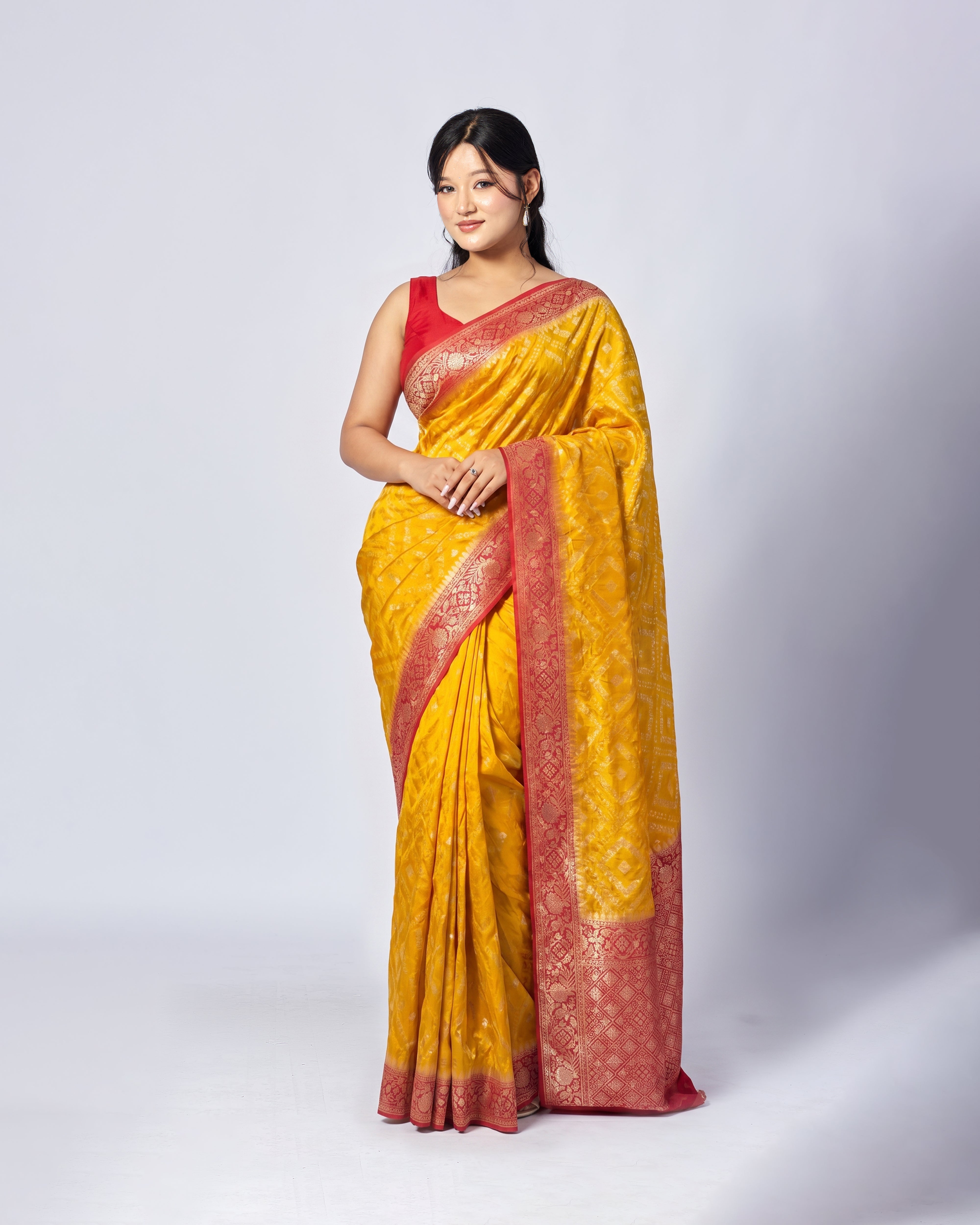 Woman wearing a yellow and red saree on a white background