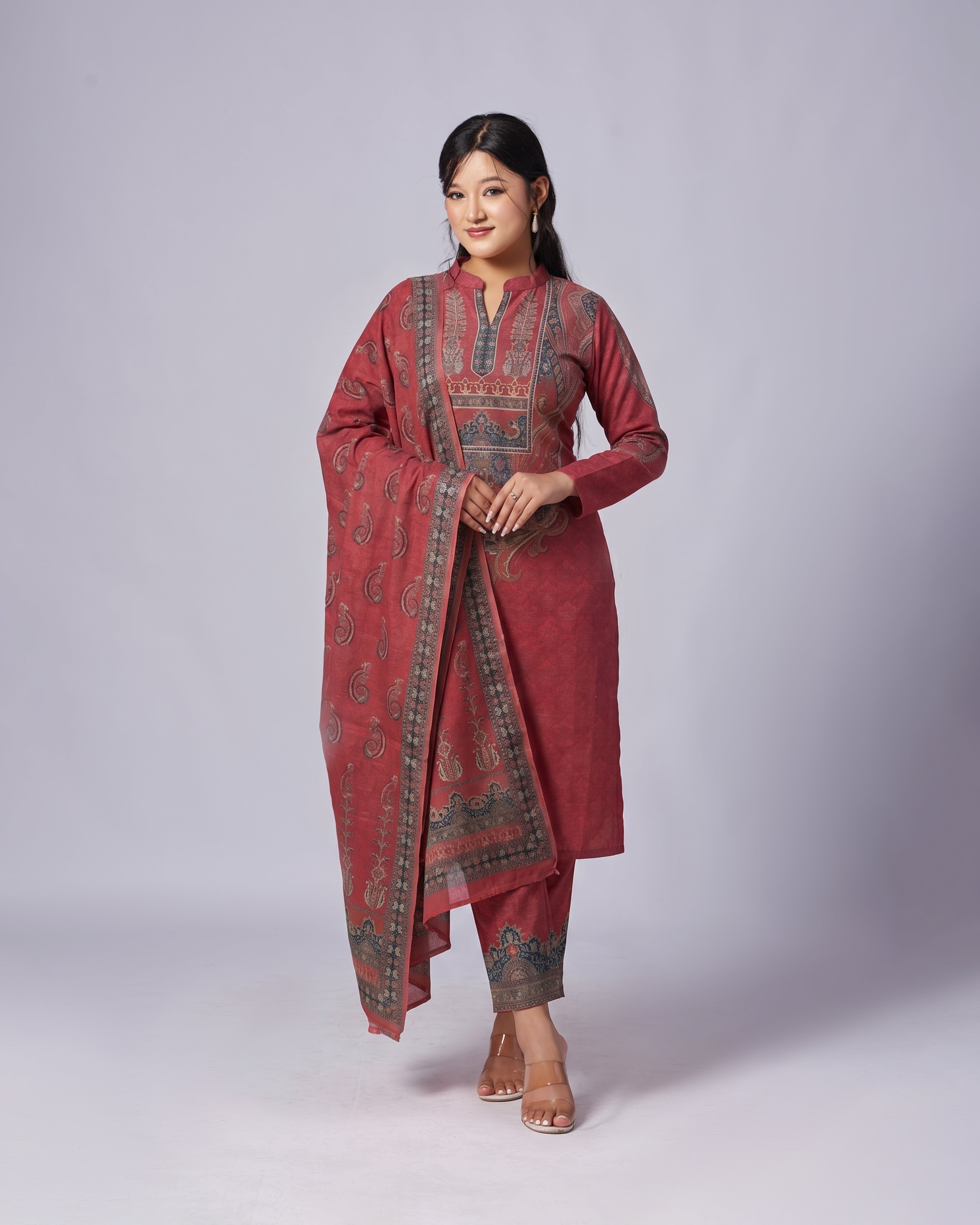Woman wearing a red traditional outfit with intricate patterns on a white background