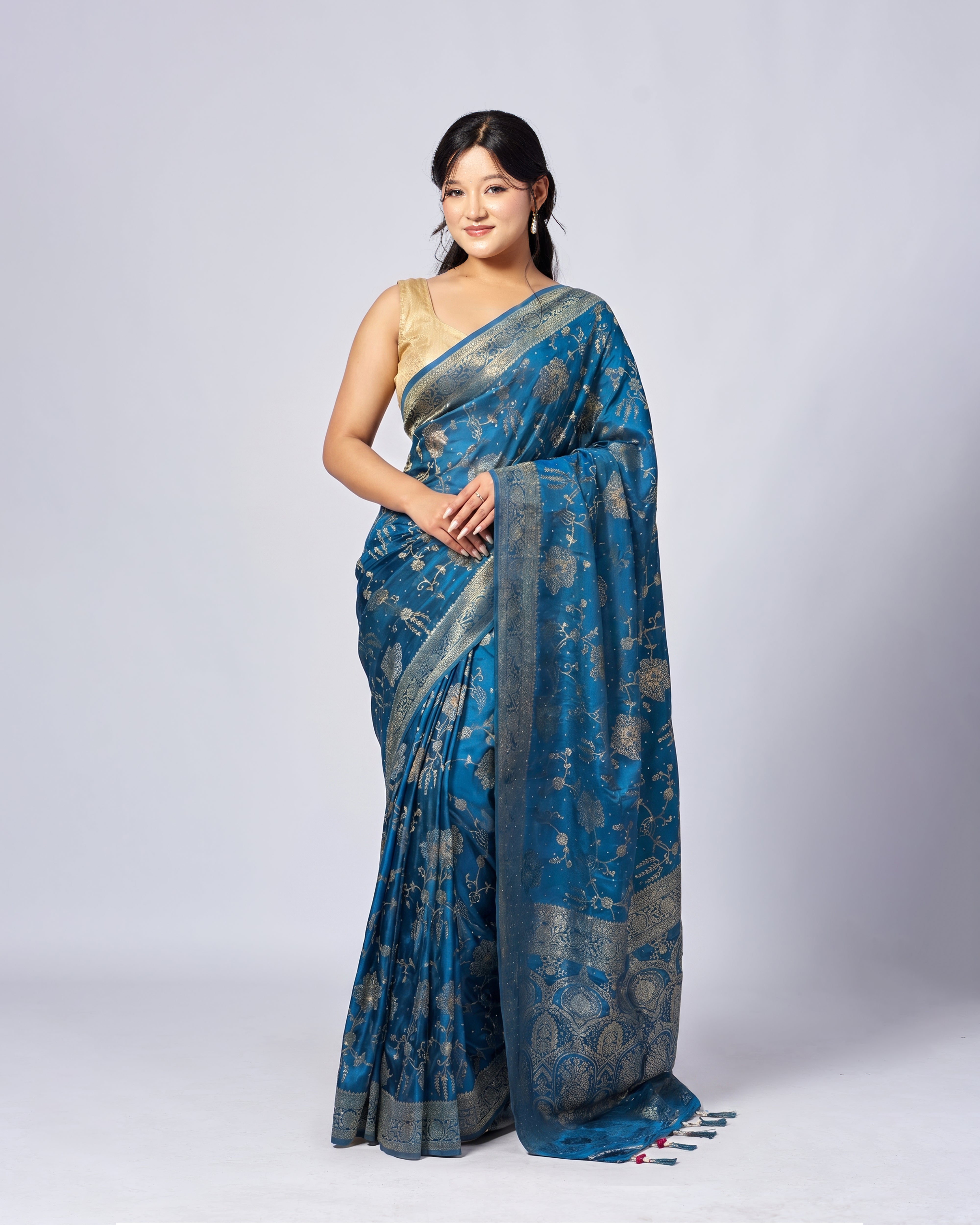 Woman wearing a blue saree with a white background