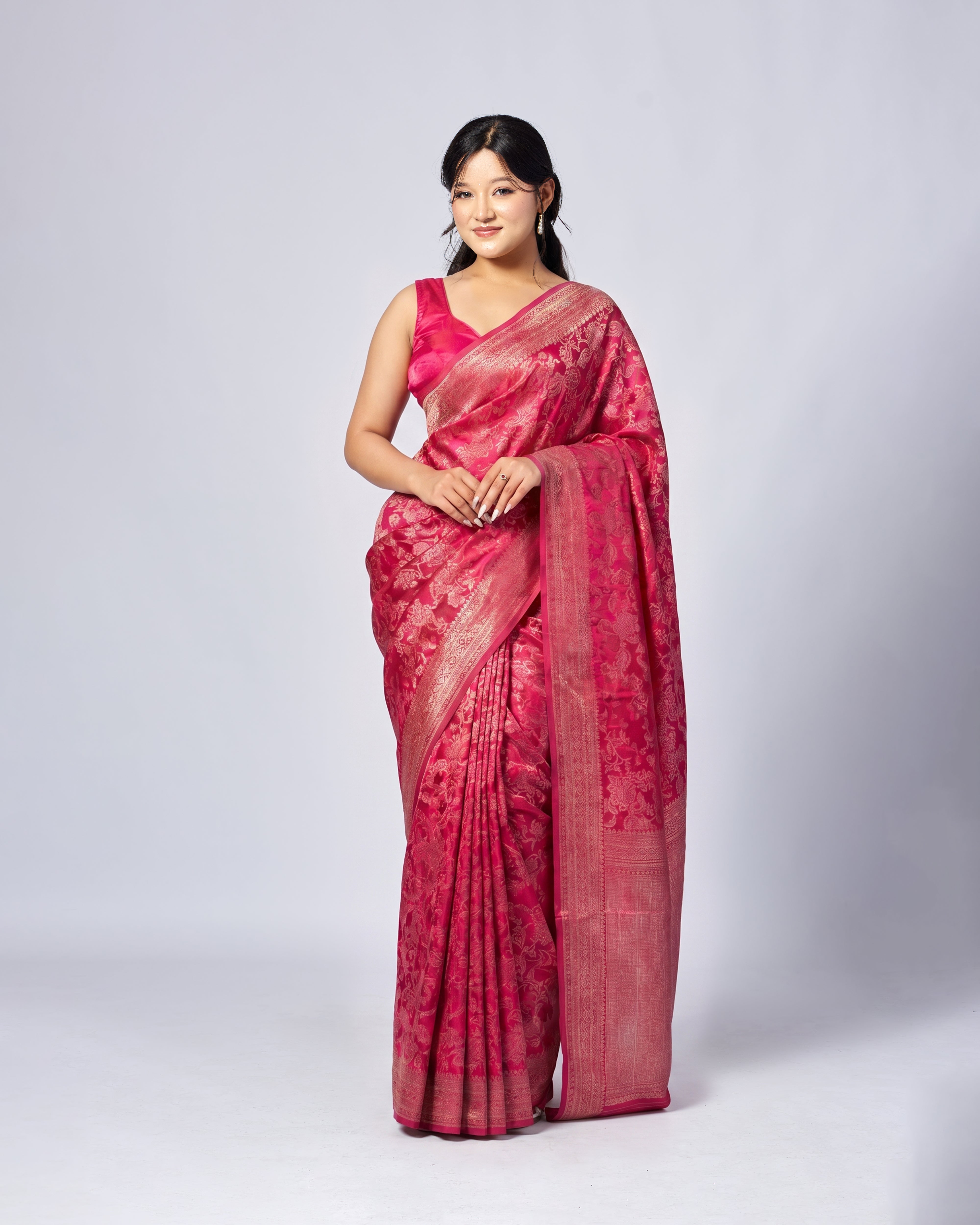 Woman wearing a pink saree with a white background