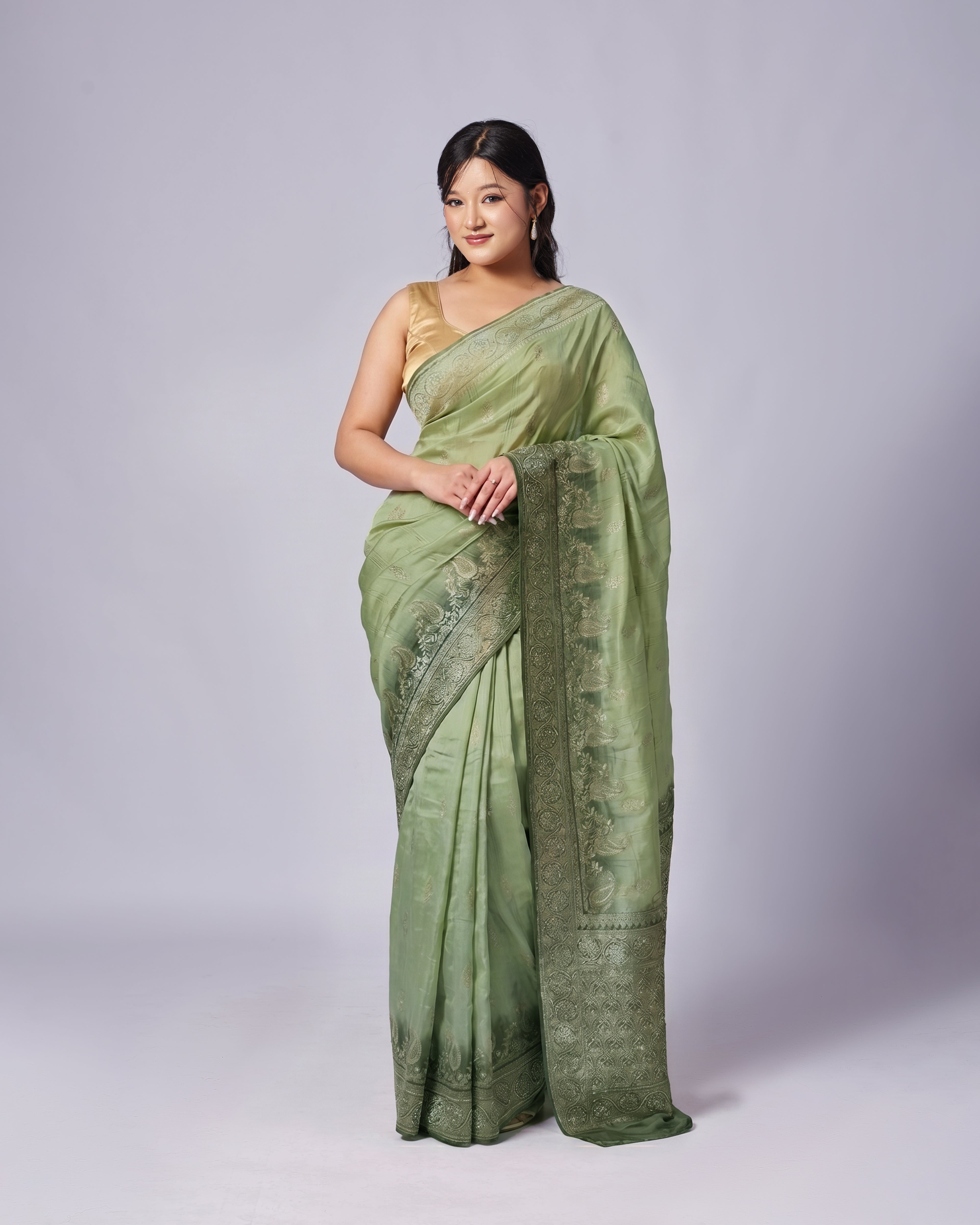 Woman wearing a green saree with a white background