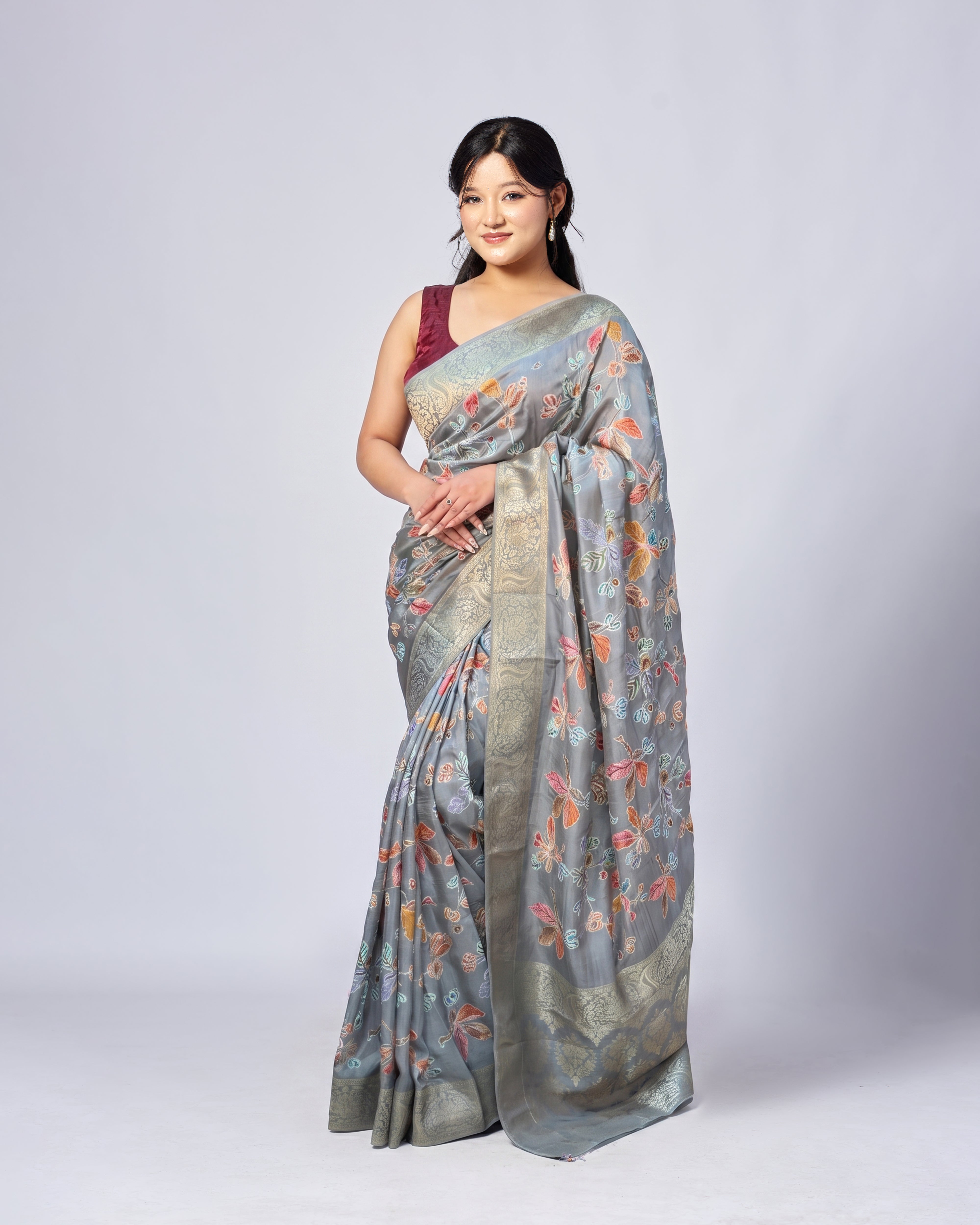 Woman wearing a floral saree with a plain background