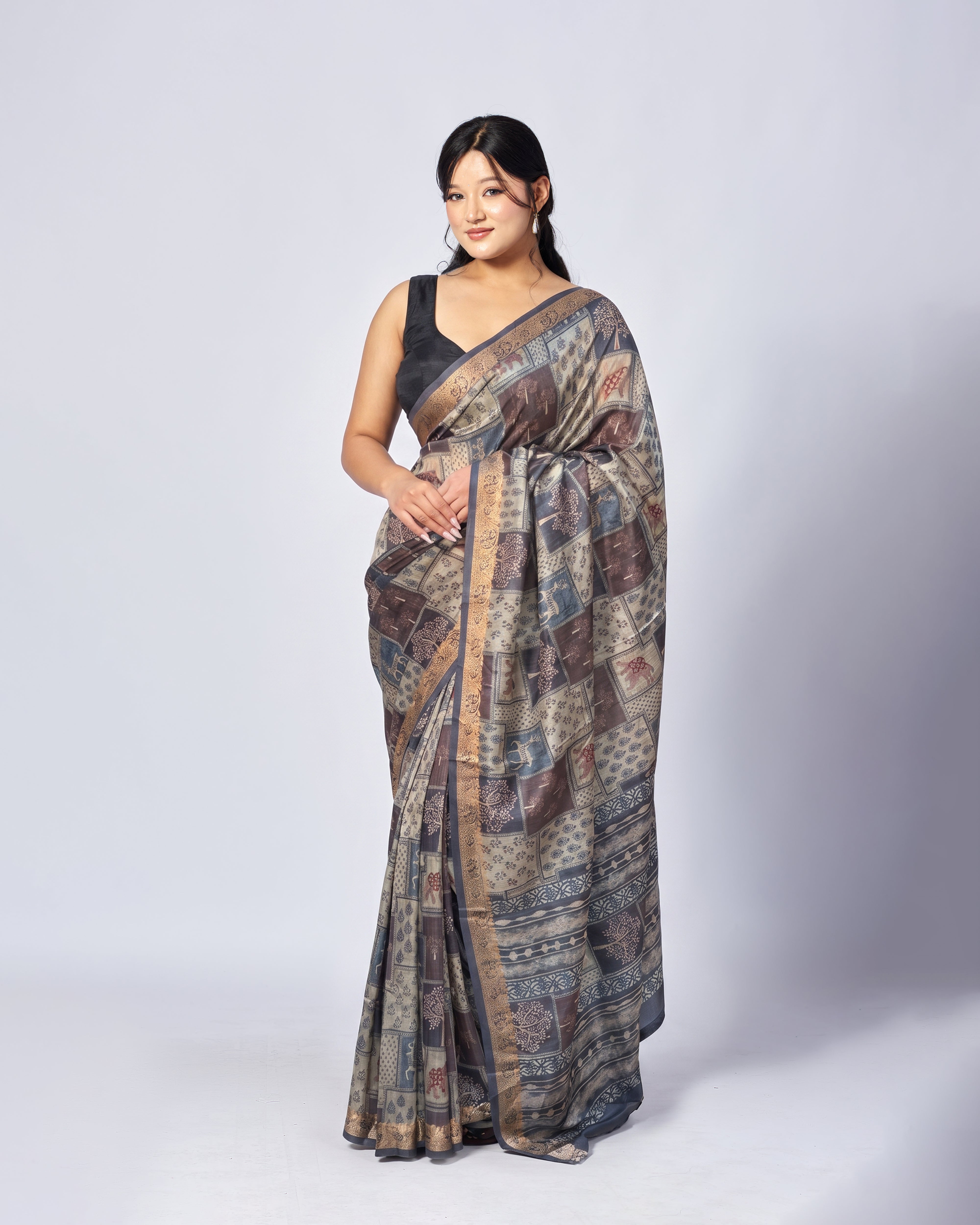 Woman wearing a patterned saree on a white background
